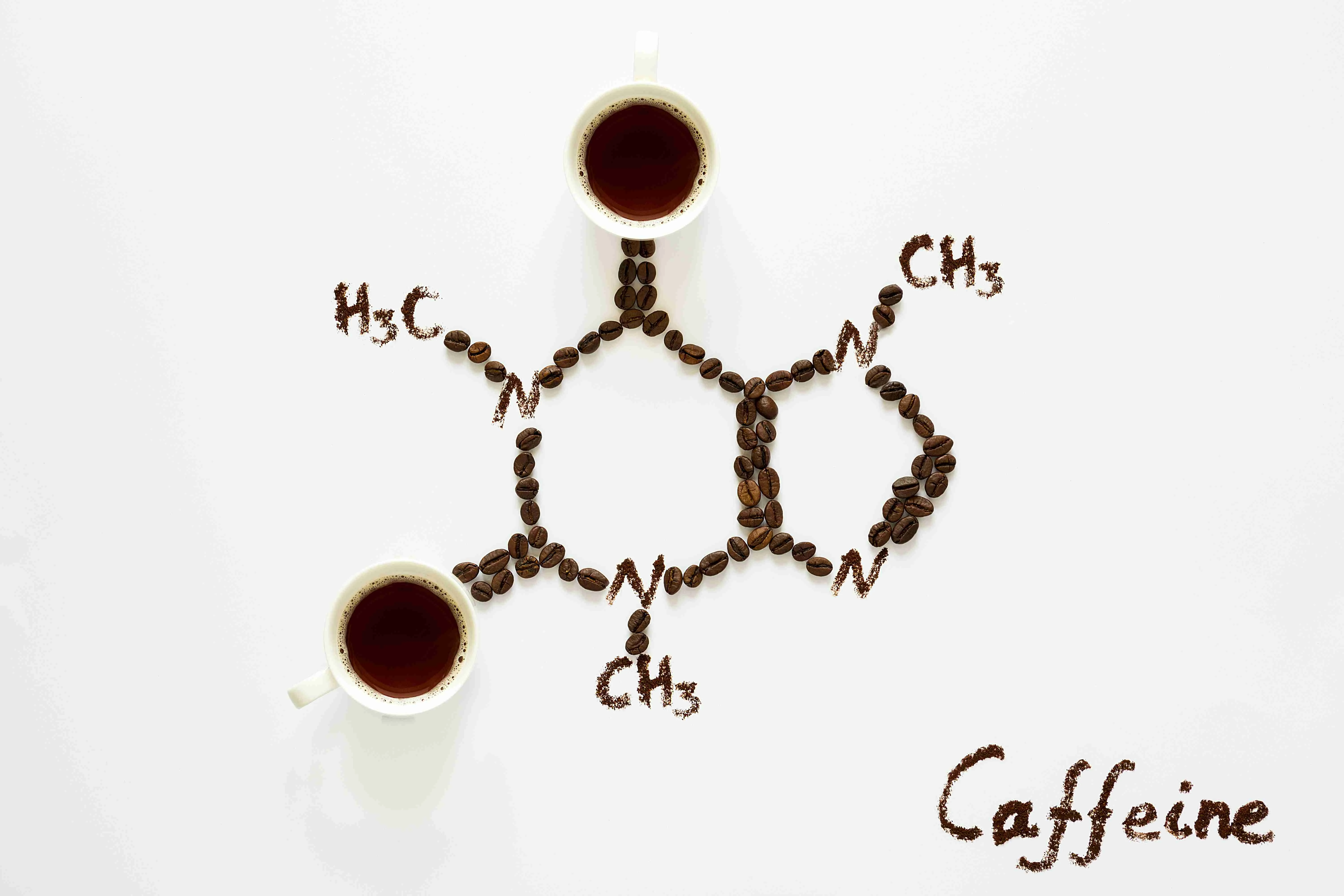 Chemical formula of Caffeine. Cups of espresso, beans and coffee powder. Art food. Top view.