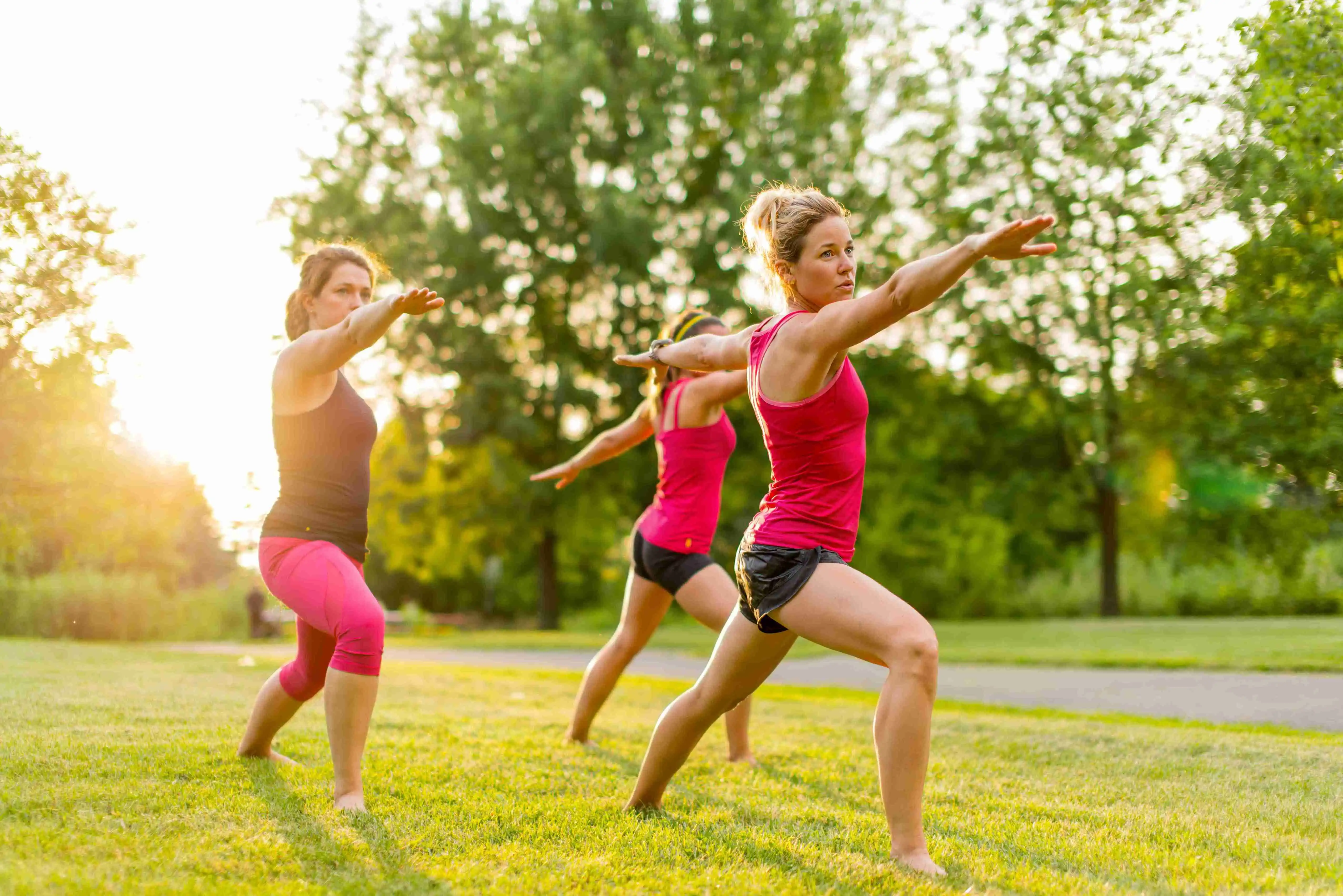 group of 3 women doing yoga in nature