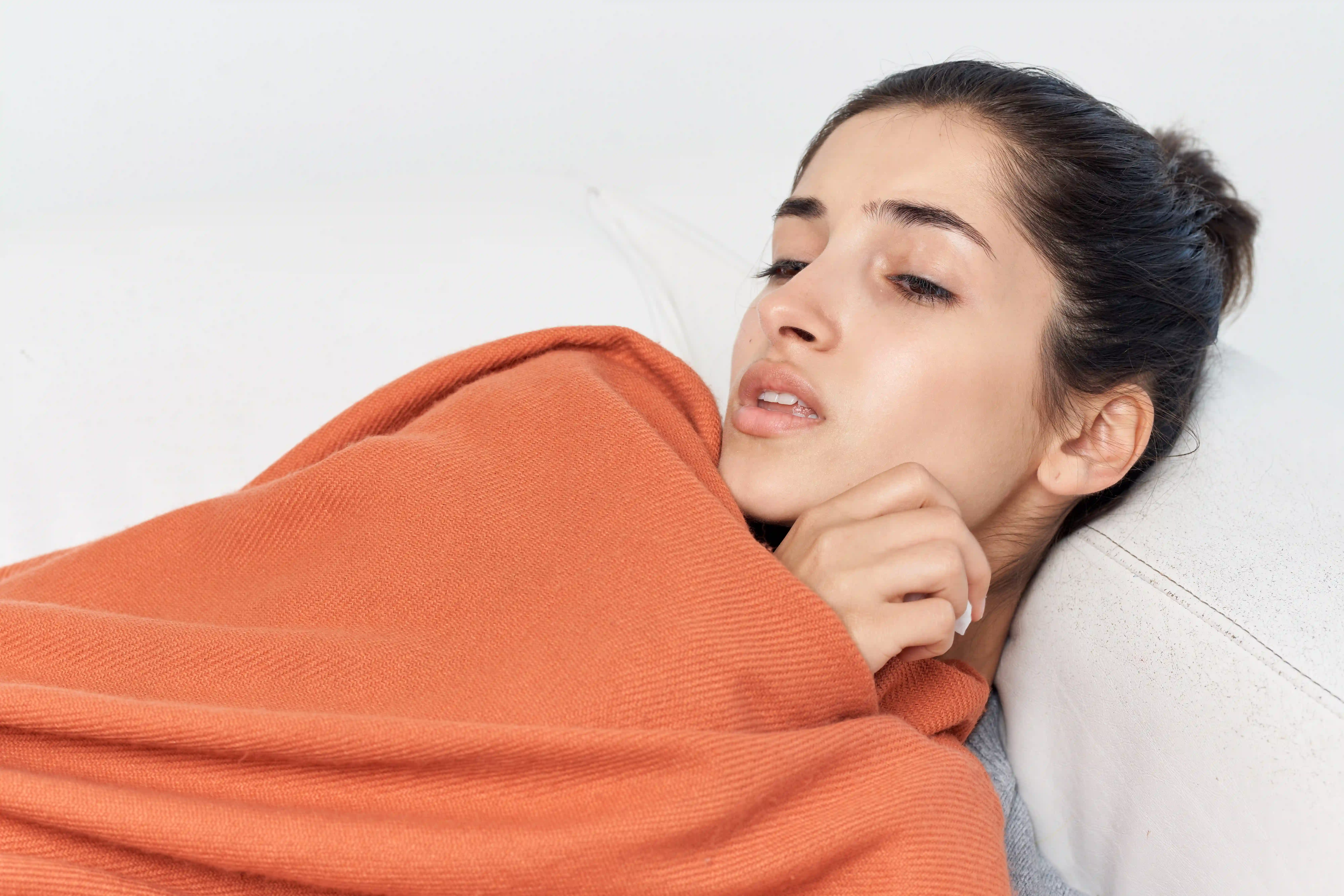 woman lying on bed feeling unwell from health problem