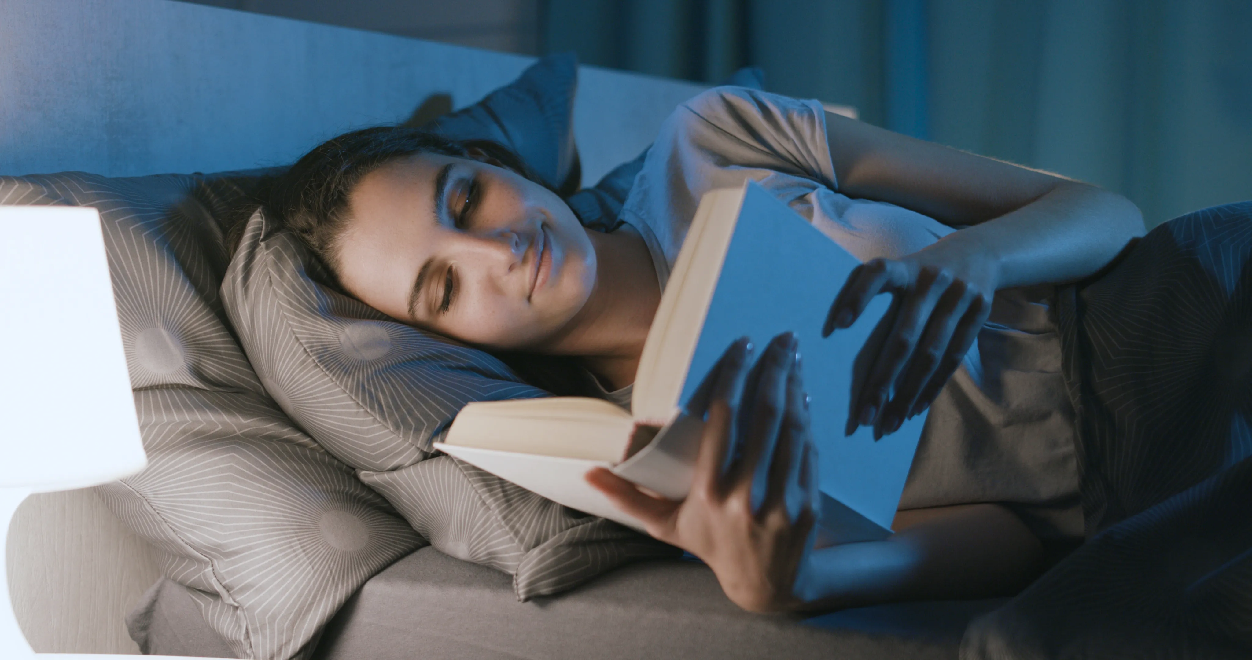 Woman lying in bed and reading a book