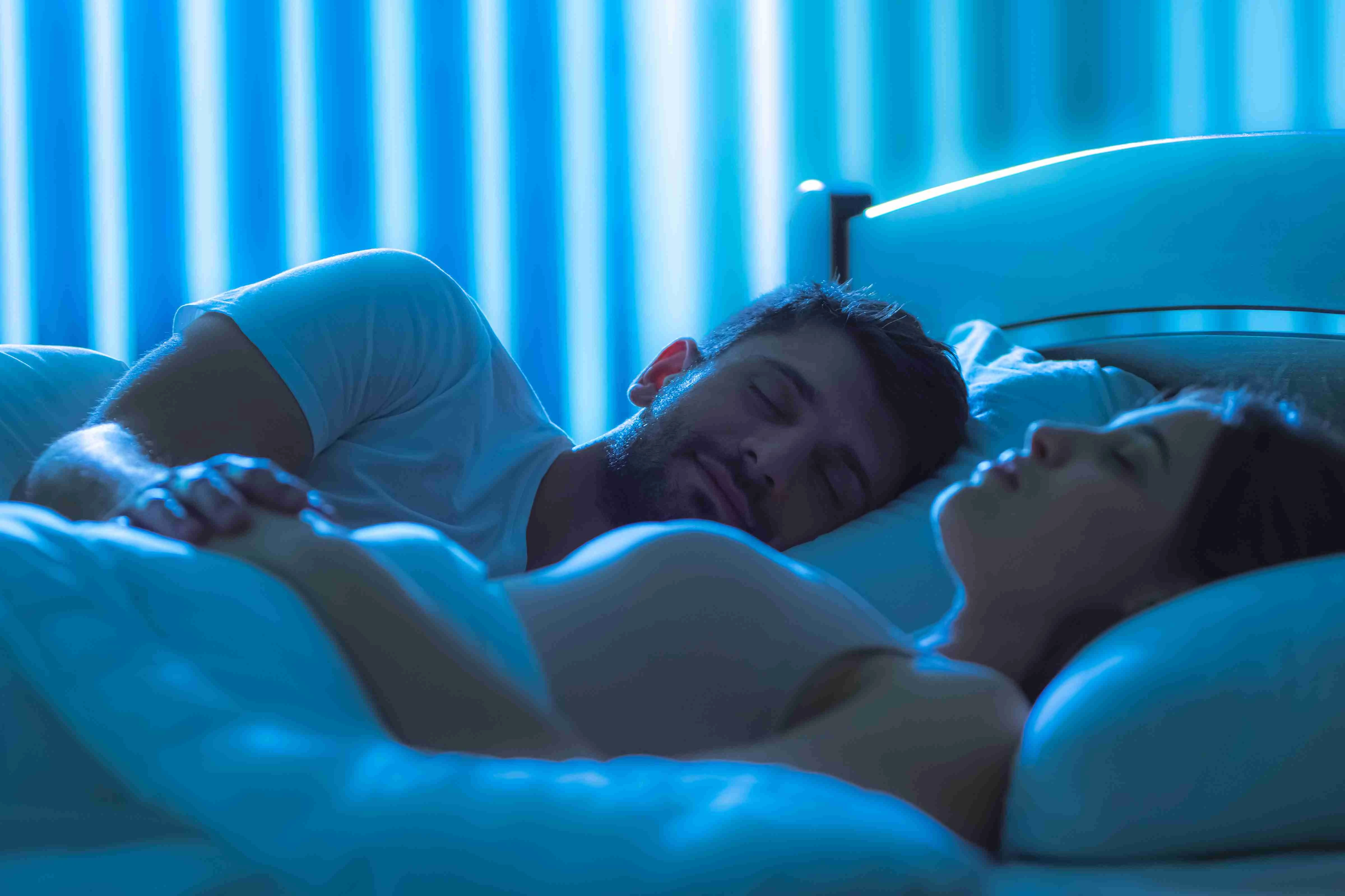 The man sleeping near the woman in the bed. night time