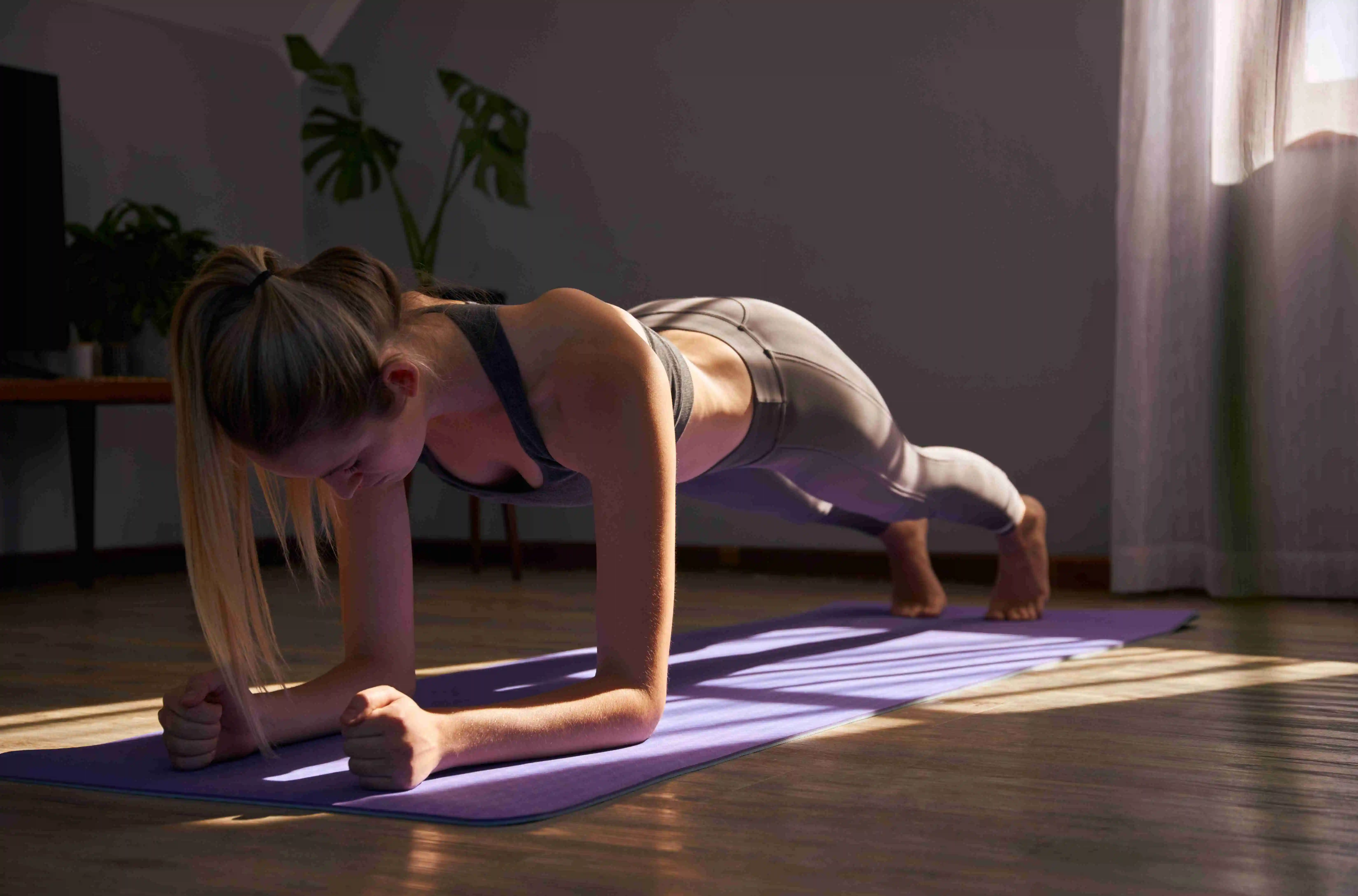 Young female stretching on yoga mat