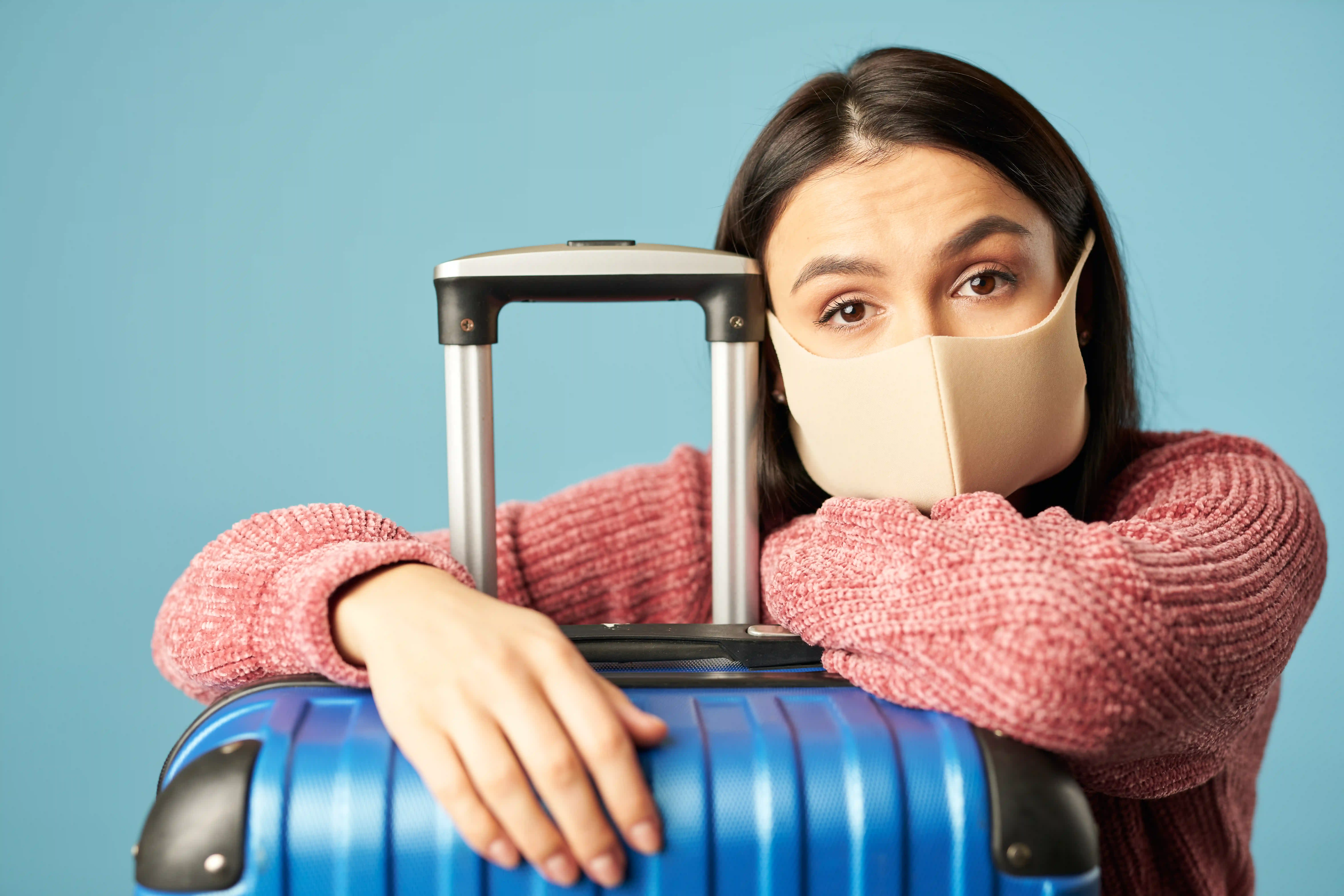 Young woman posing with travel luggage