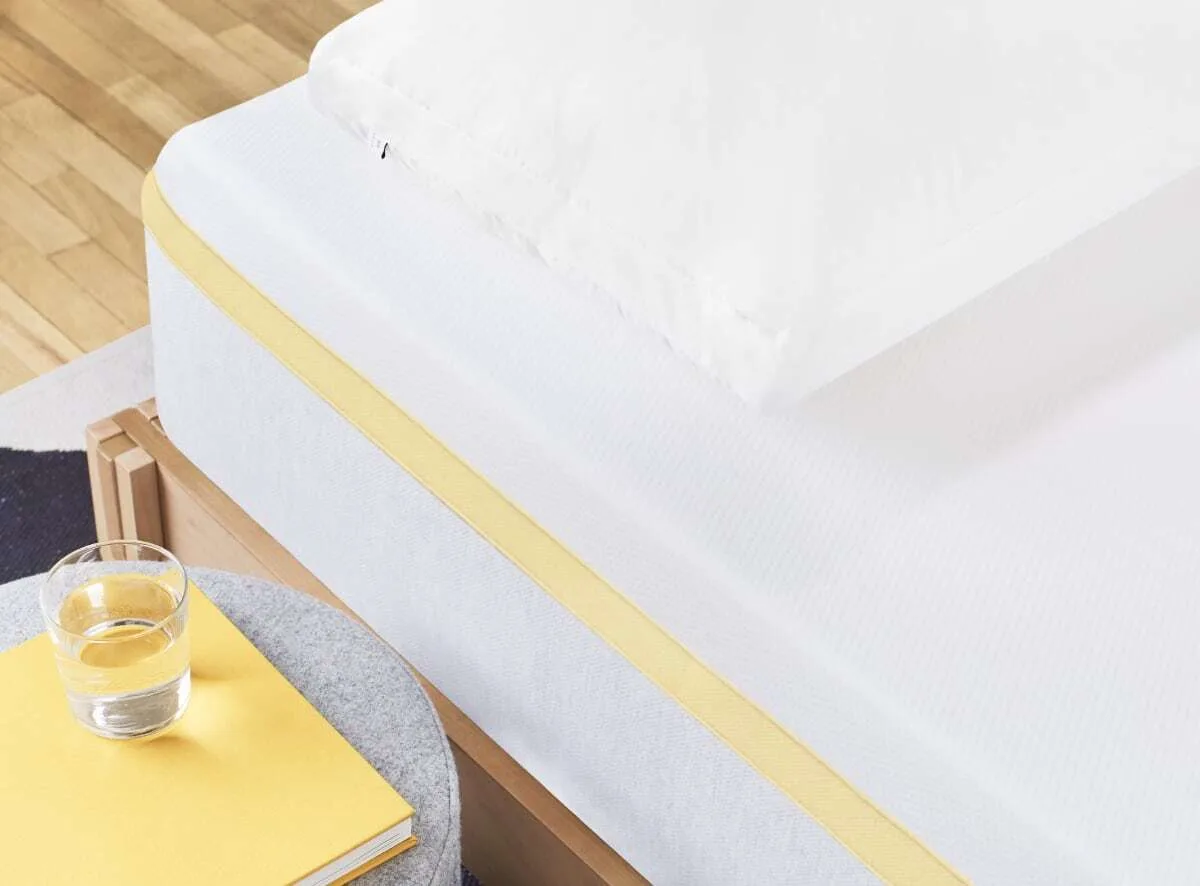 Helix Dawn mattress with a water glass and notebook on a stool