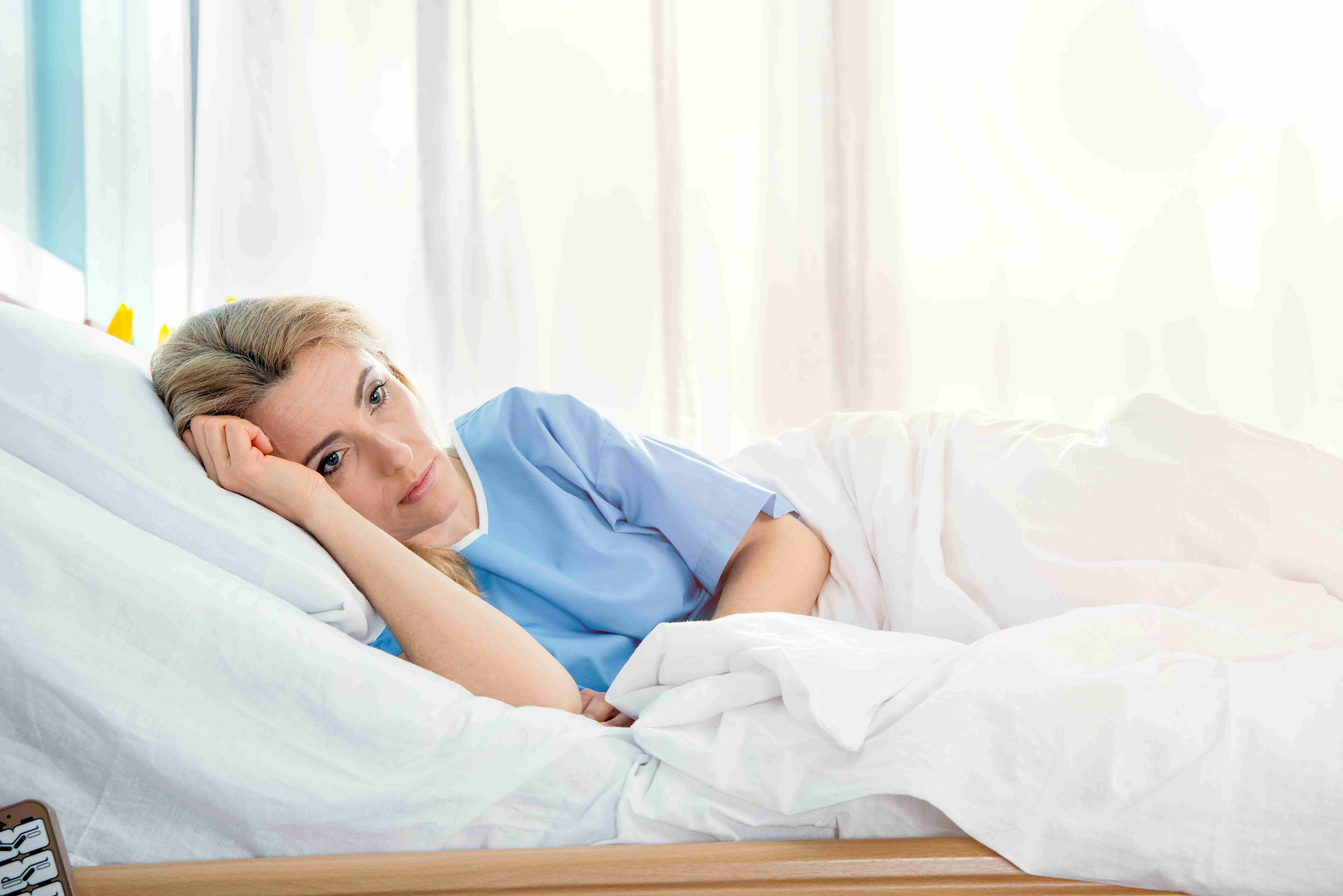 portrait of pensive woman lying in hospital bed