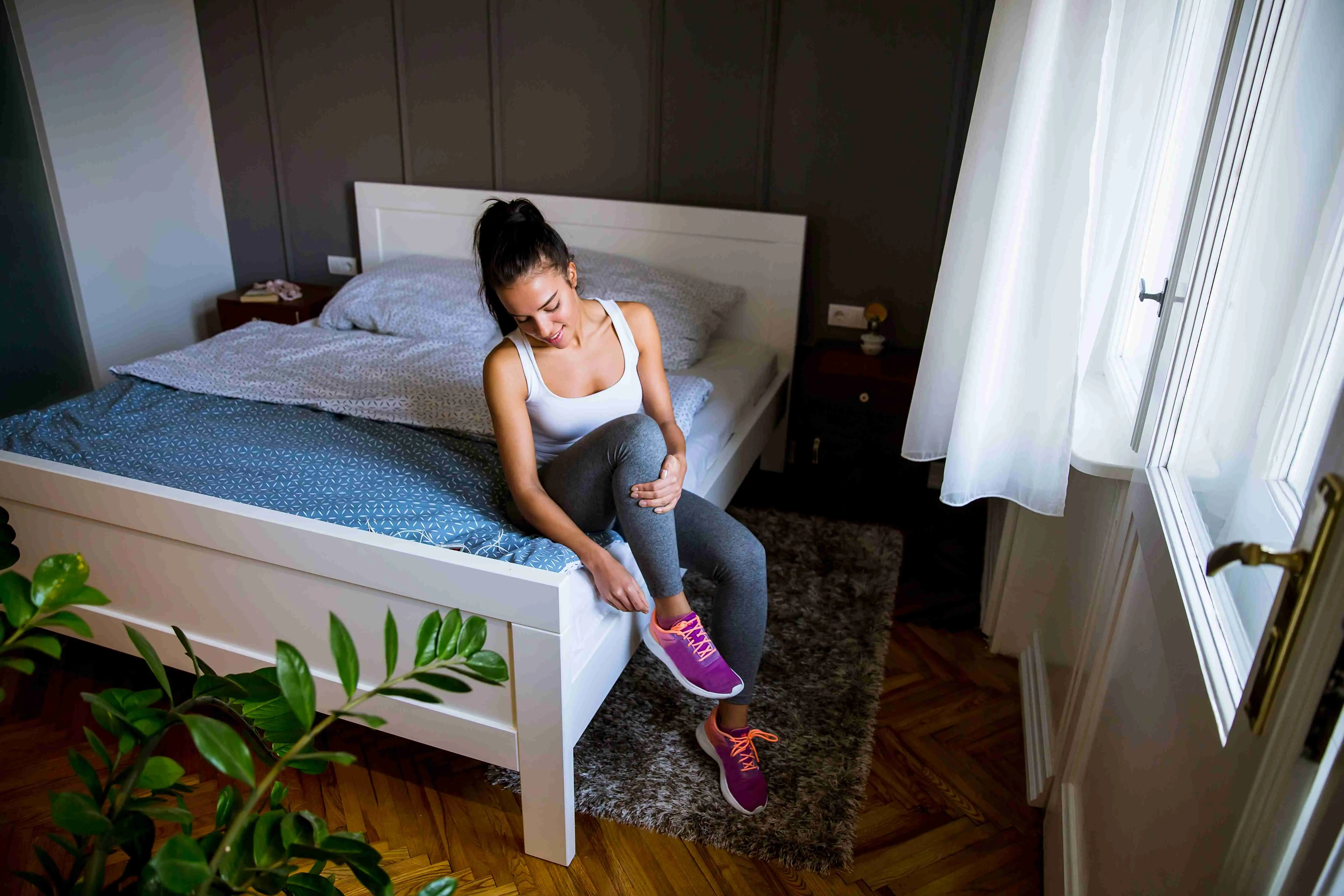 Young attractive woman preparing for exercises at home