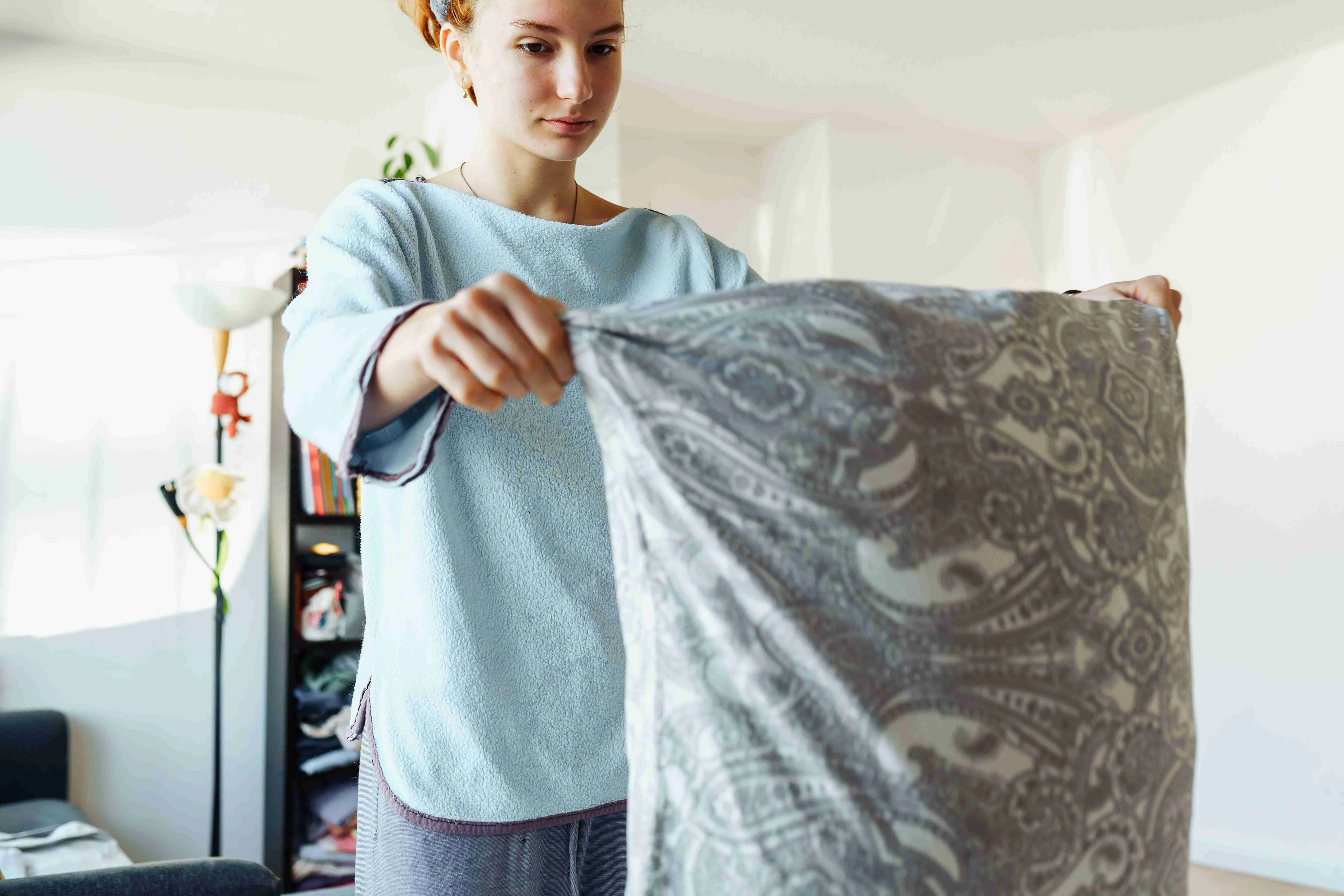 Woman puts clean pillowcase on pillow