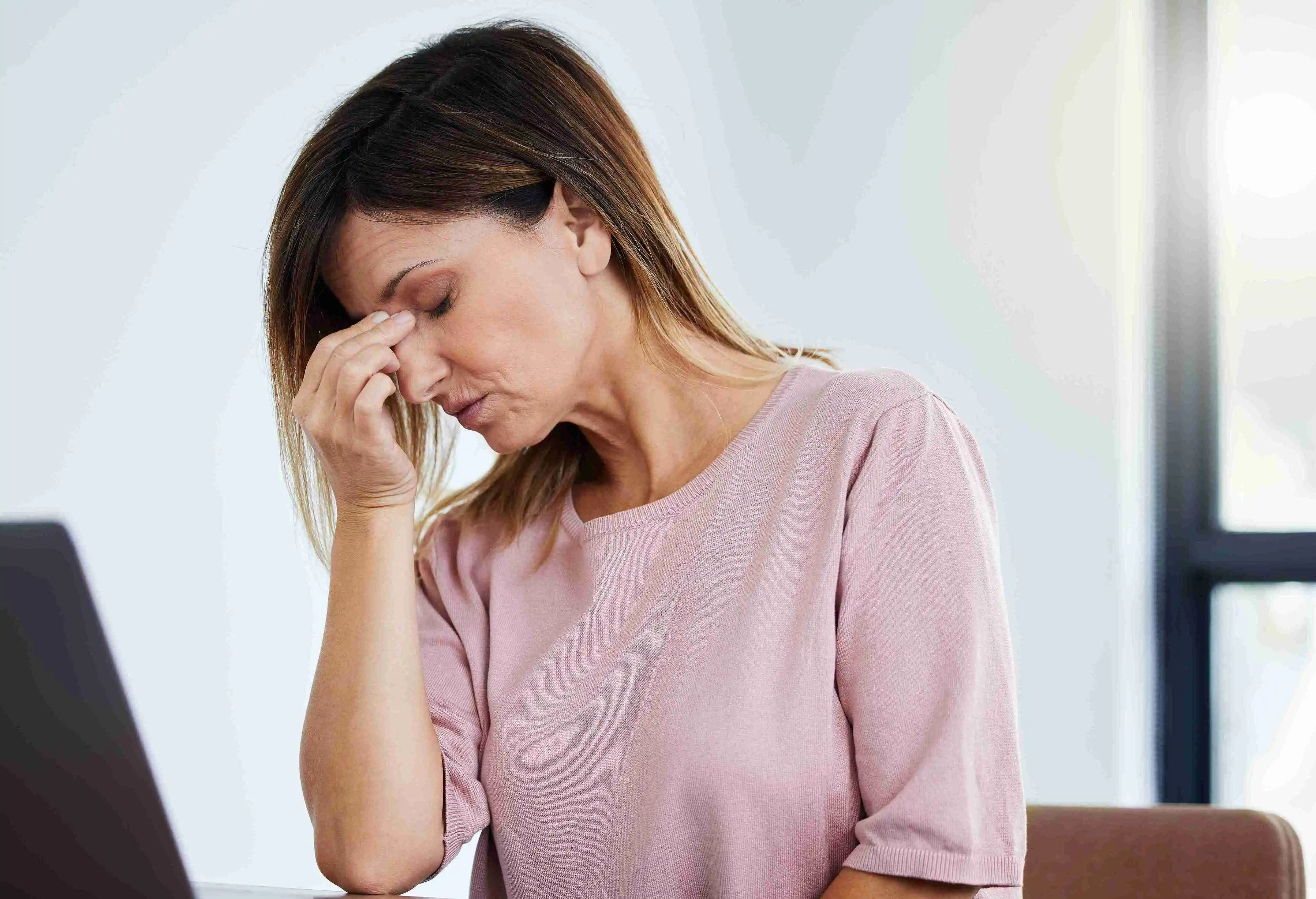 Shot of a female manager experiencing a headache at work