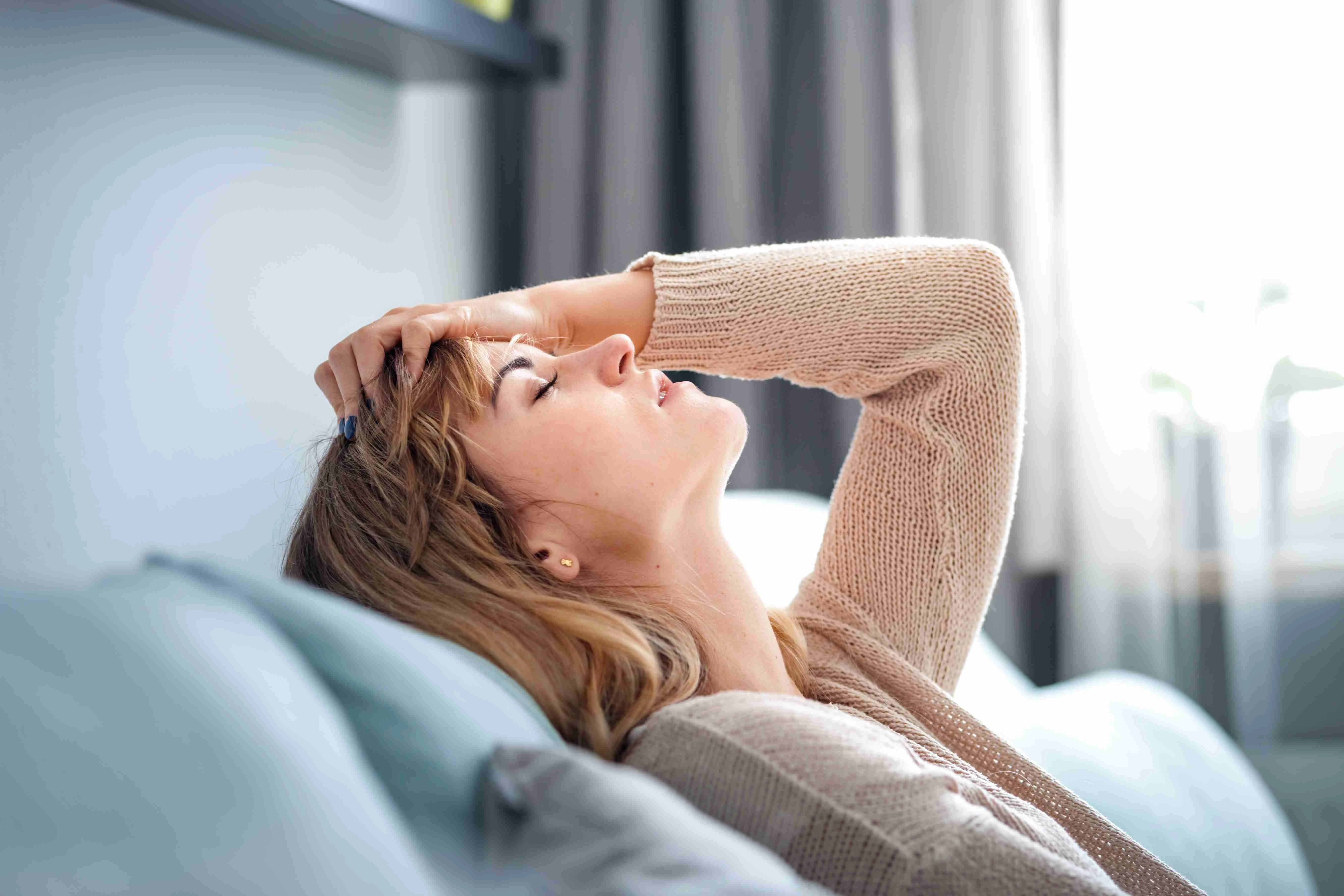 Depressed woman sitting on sofa at home