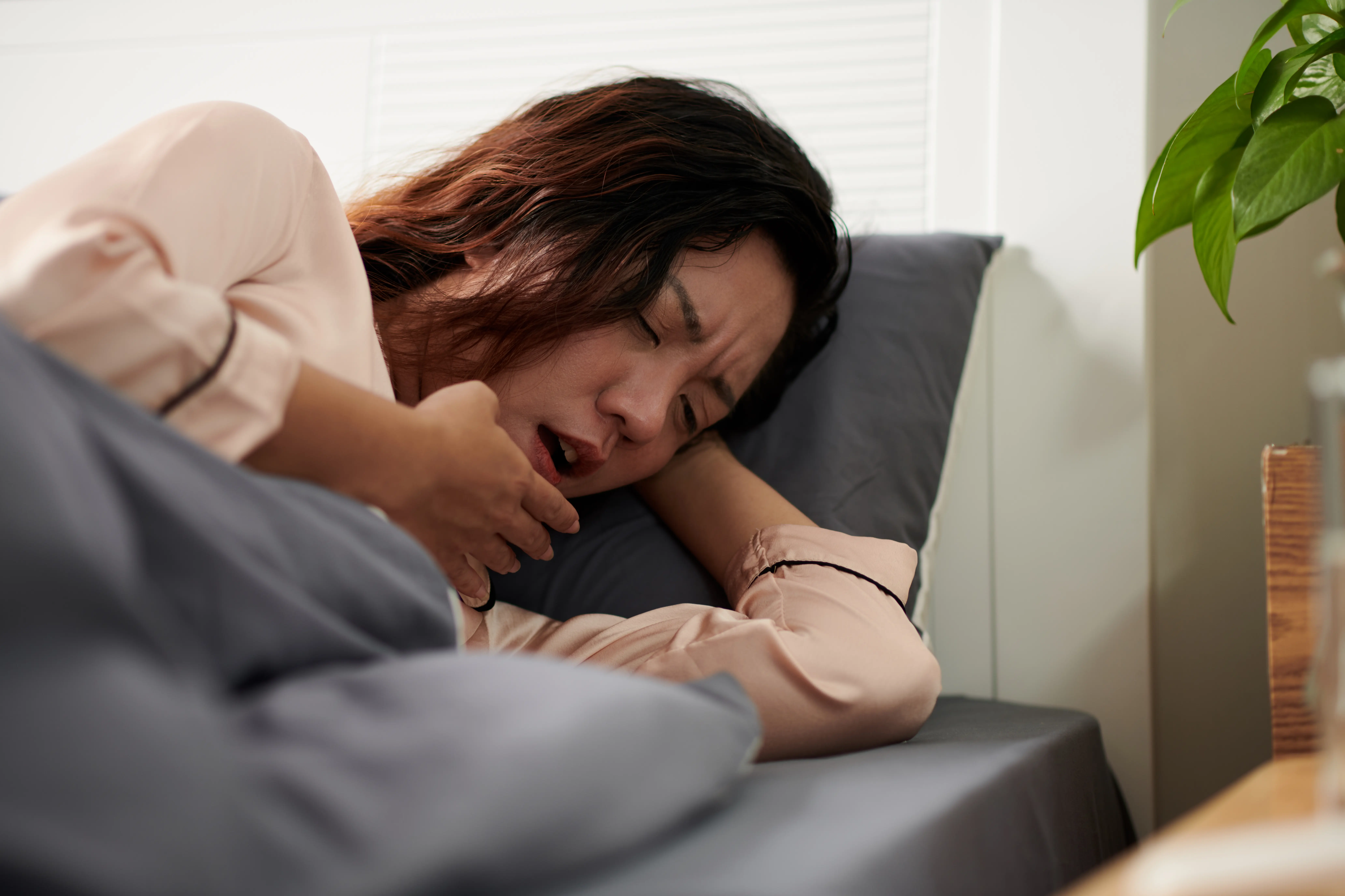 Woman Coughing in Bed