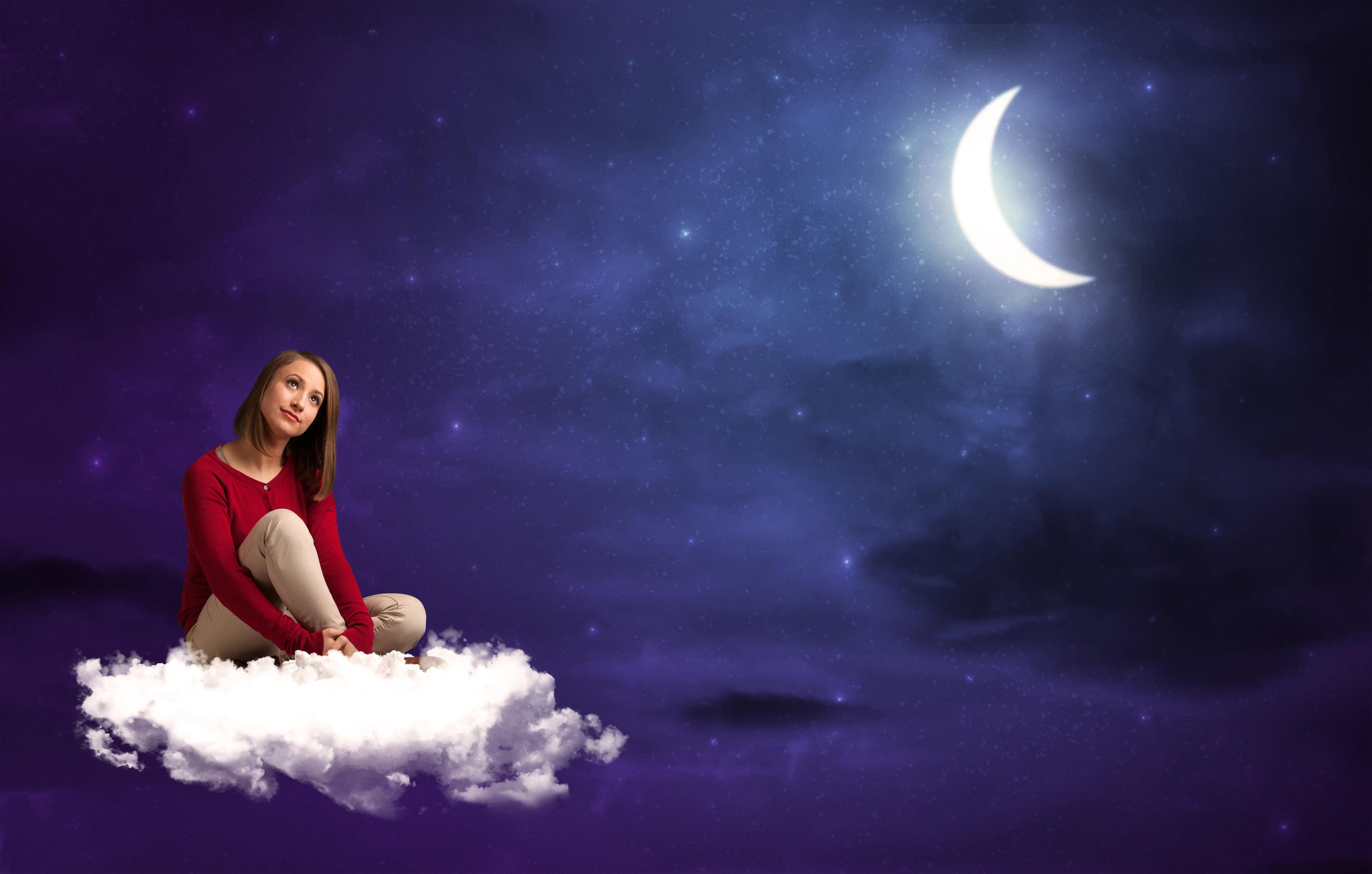 Dream symbols depend on personal and cultural context Woman sitting on a white cloud and looking thoughtful under moonlight