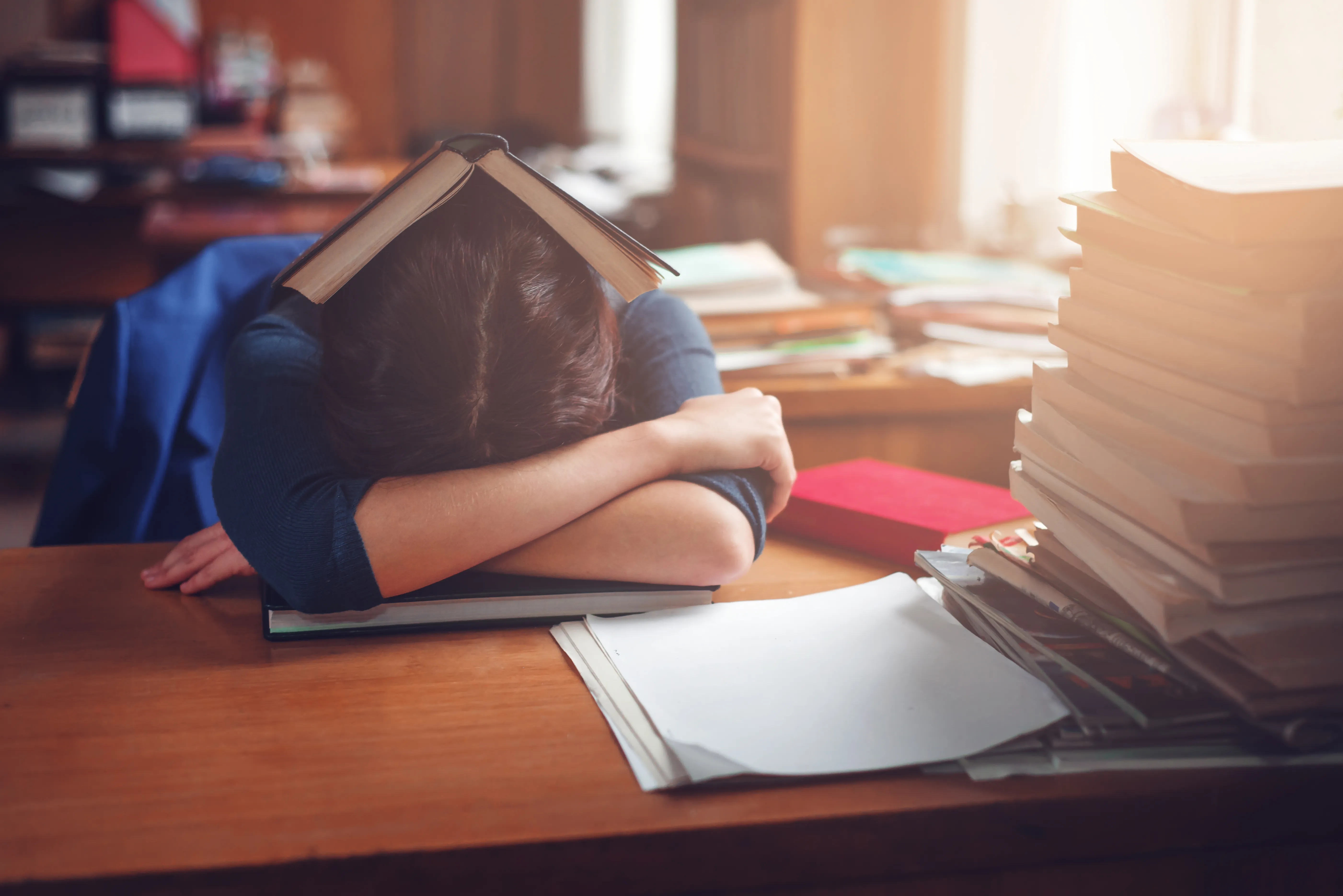 Woman sleeping with a book on her head.