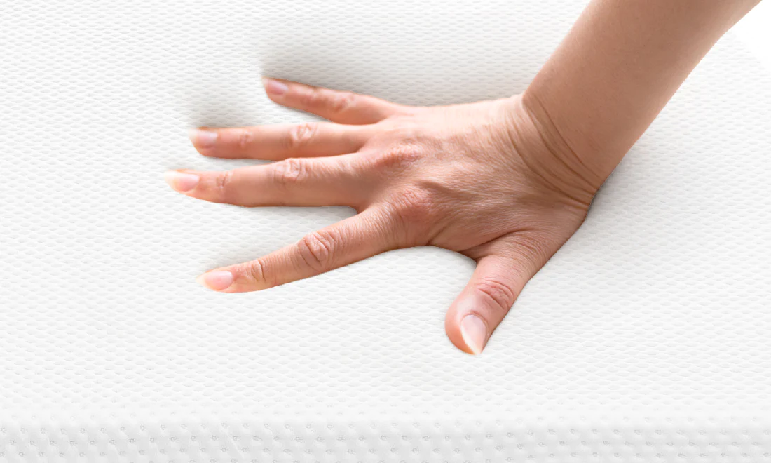 A reviewer hand pushing emma original mattress