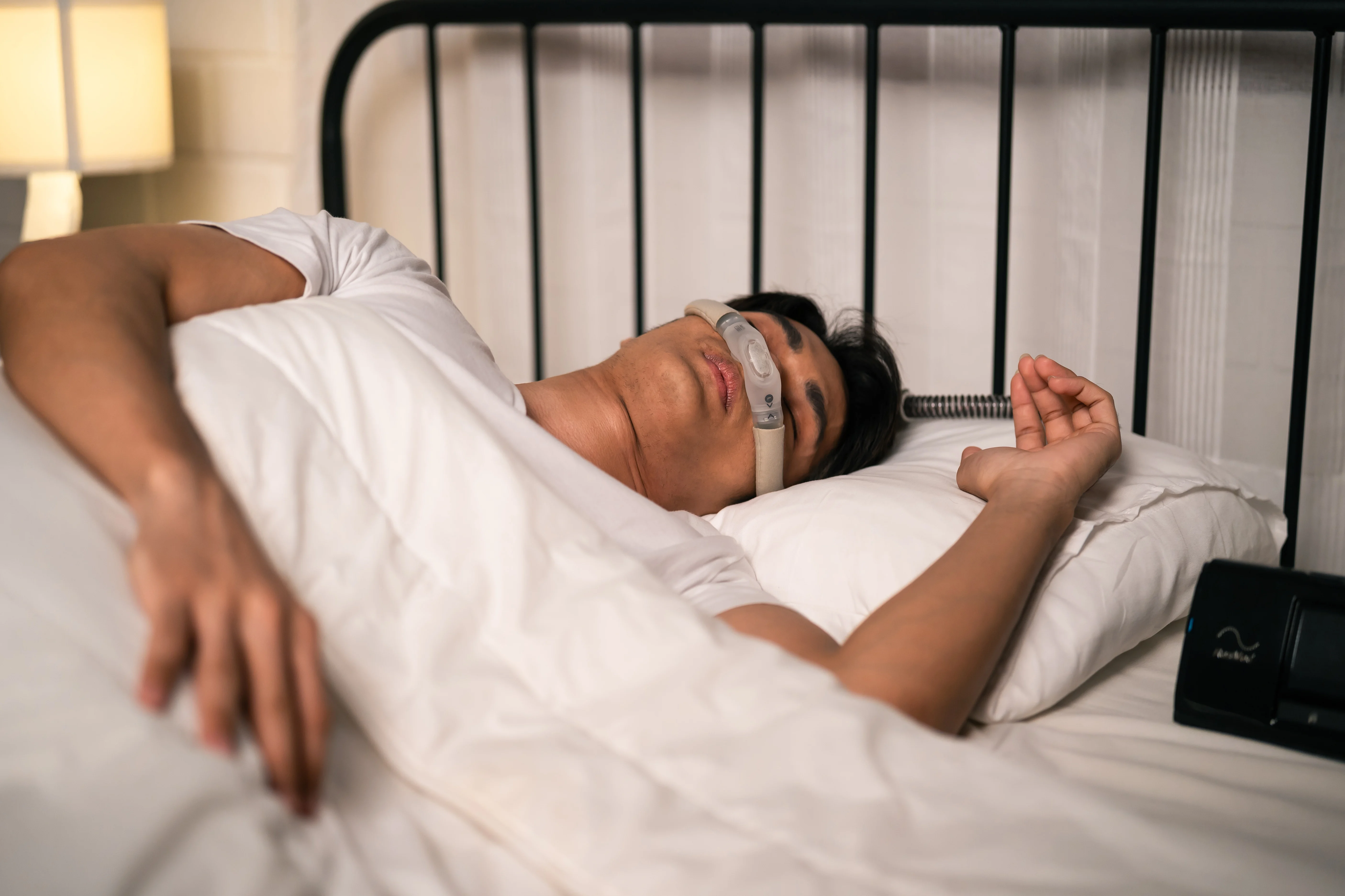 Man Sleeping Comfortably with CPAP Mask in Bedroom