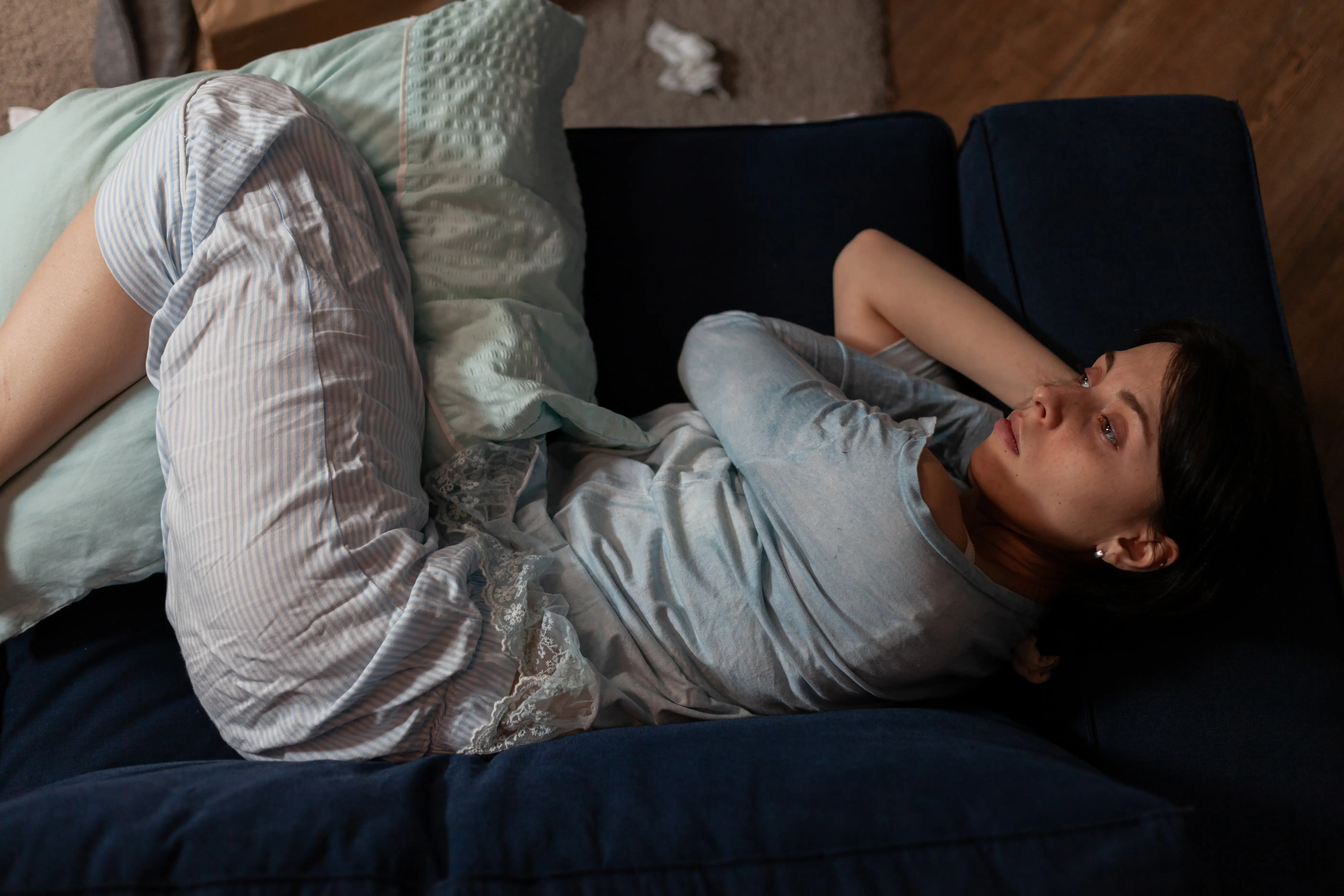 woman with anxiety laying on couch