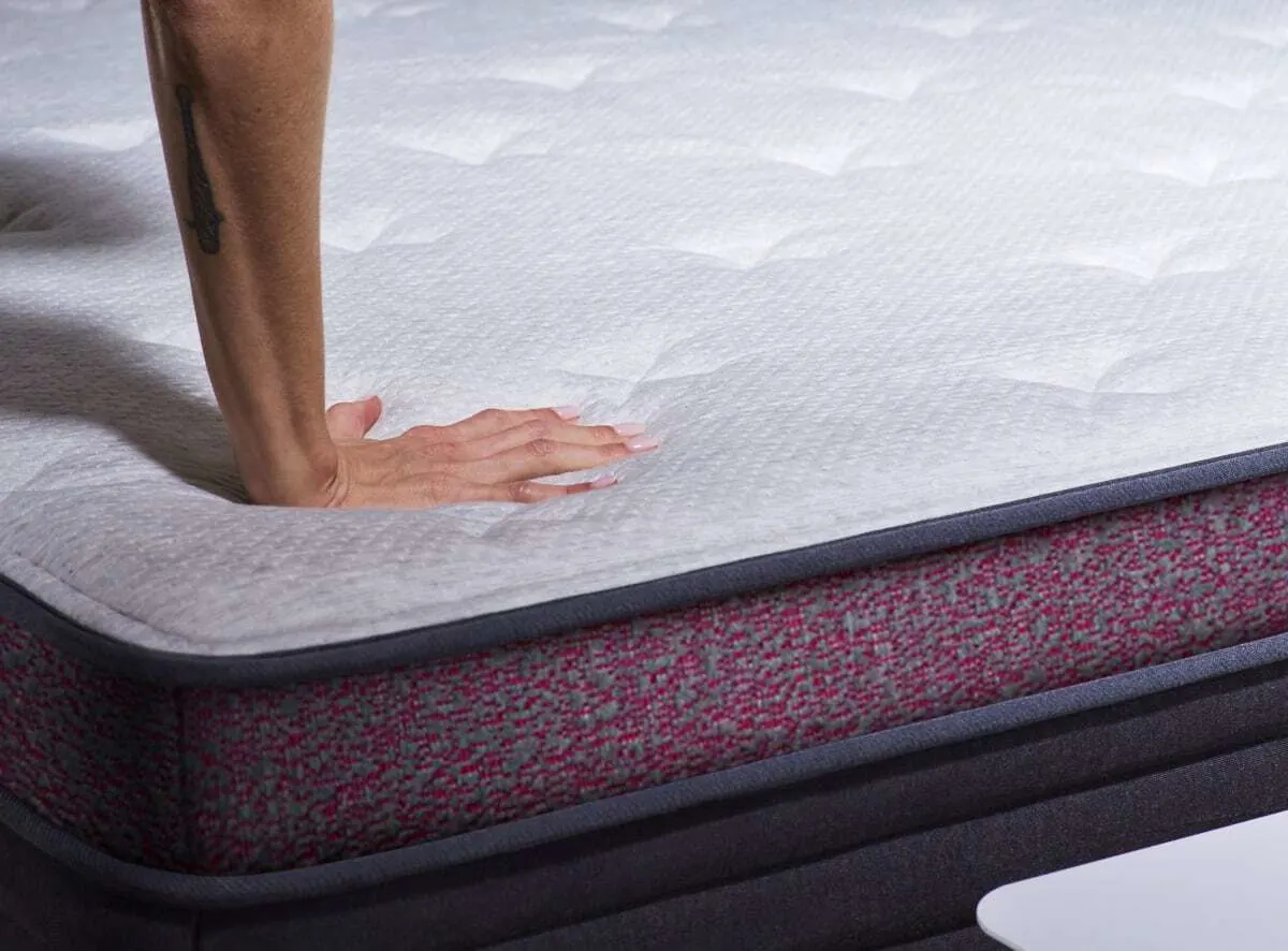 Reviewer hands on the edge of Helix Dusk Luxe Mattress