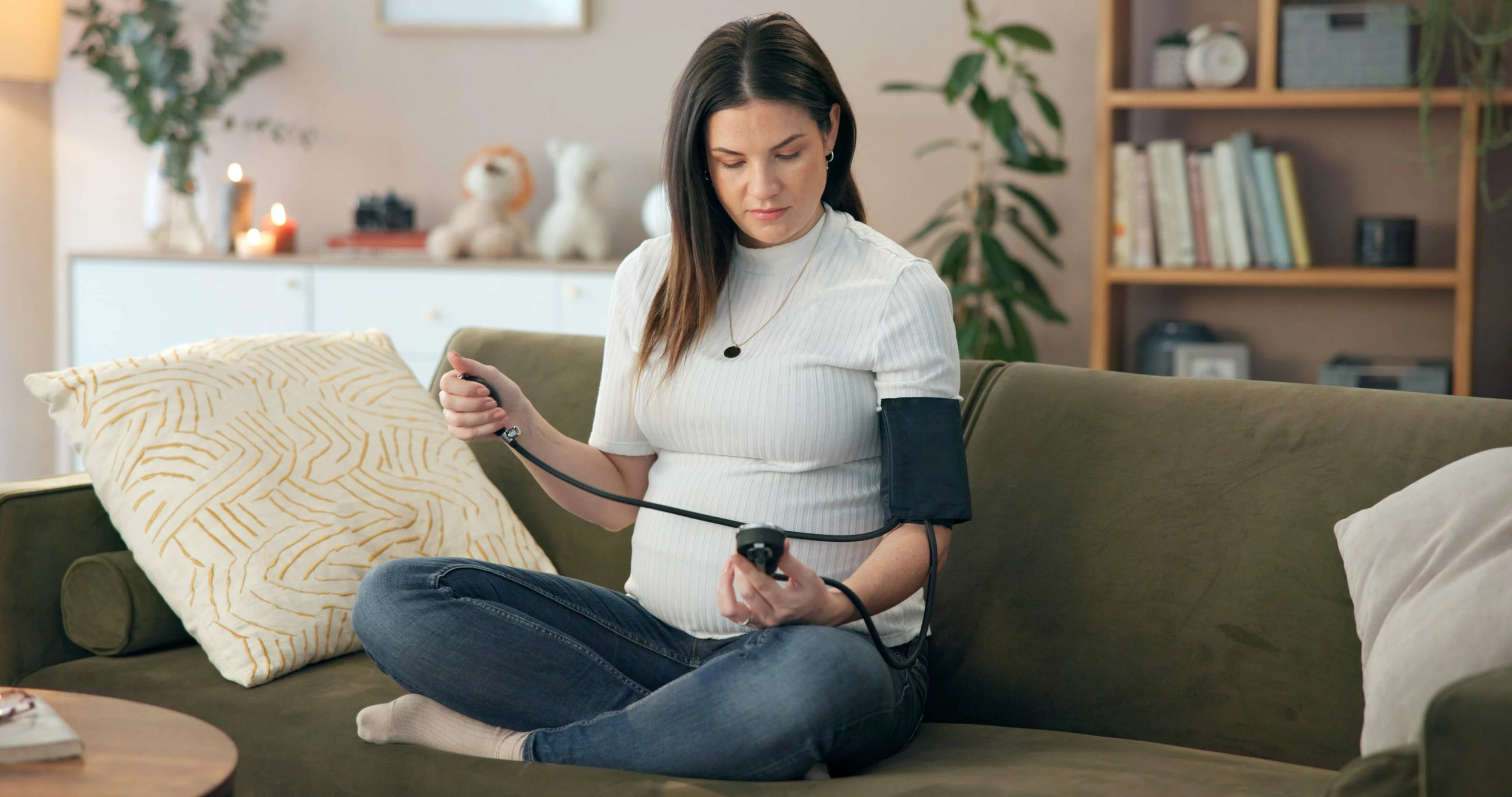 Blood pressure, monitor and check with pregnant woman on sofa for hypertension, medical and health