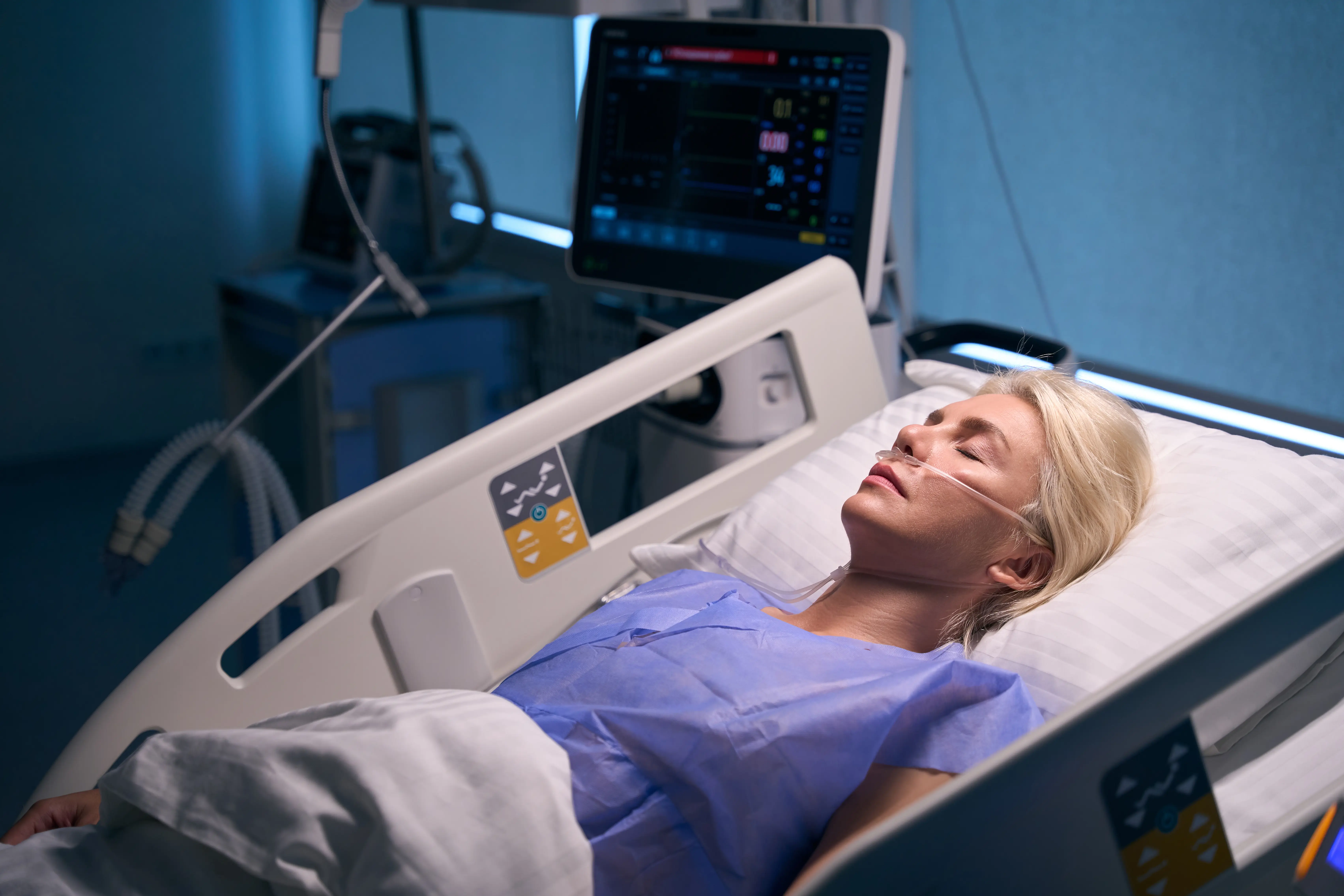 Beautiful woman lies on postoperative bed in intensive care unit