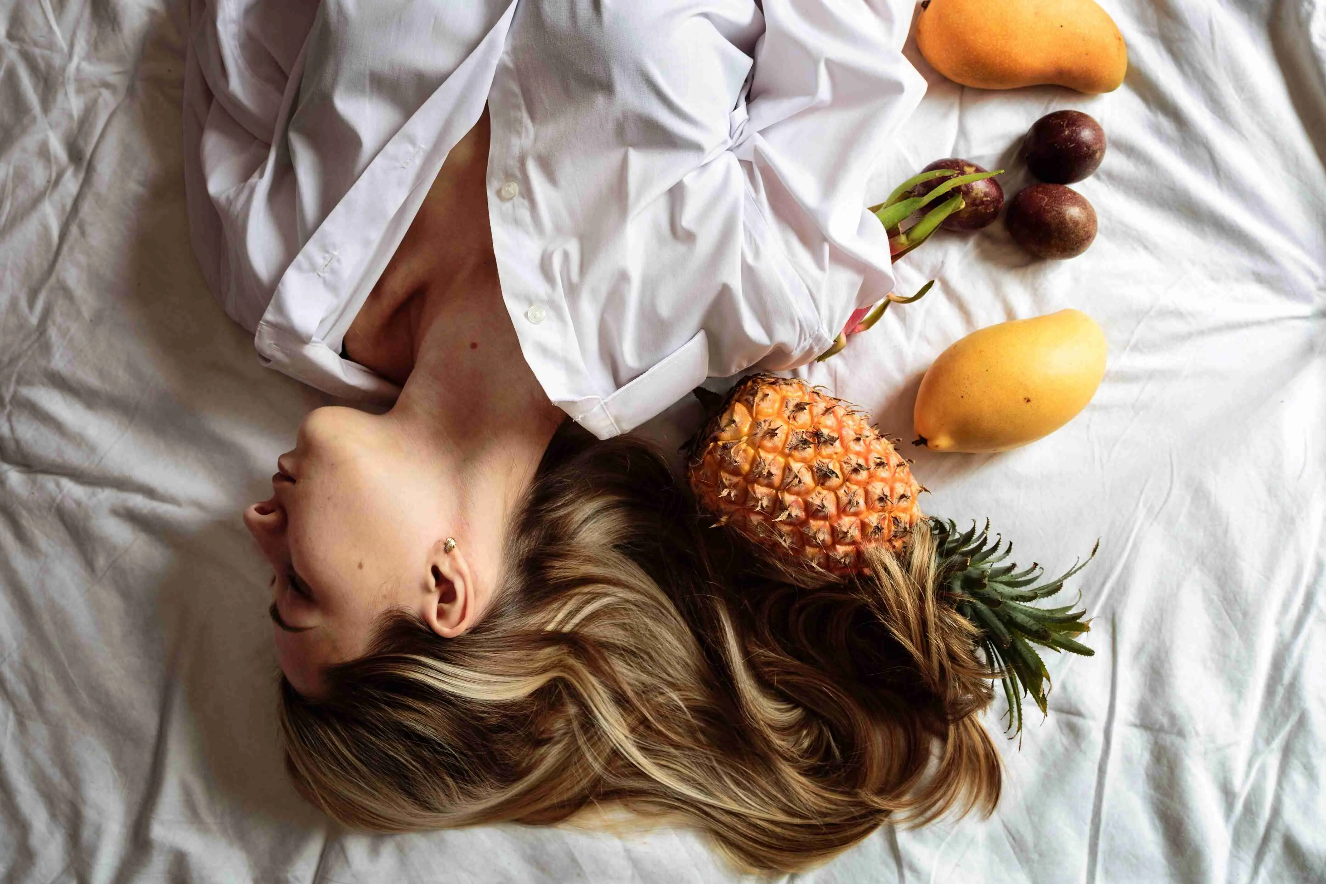 Beautiful young woman with blonde hair lying on the bed with closed eyes