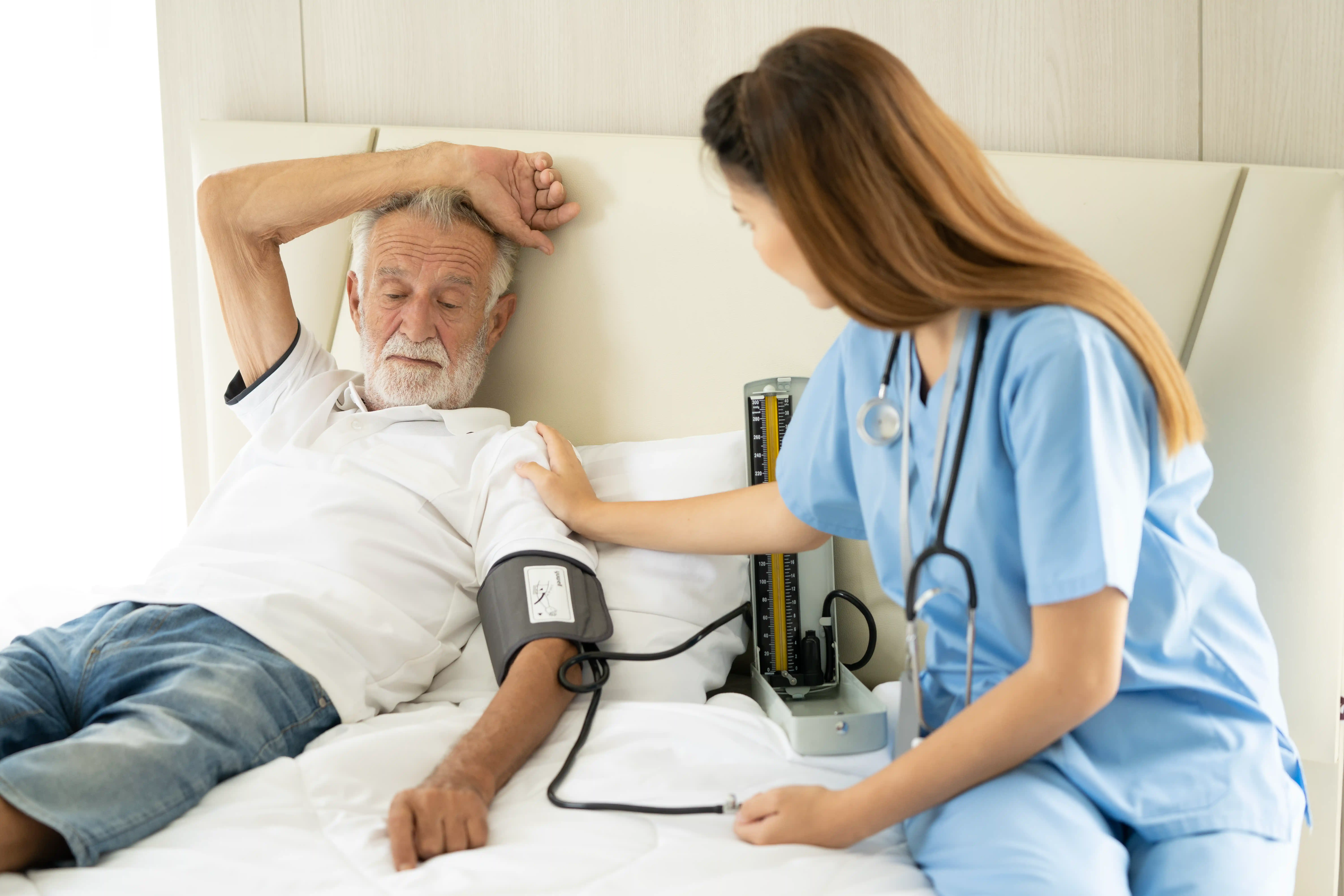 Man being cared for by a private Asian nurse at home