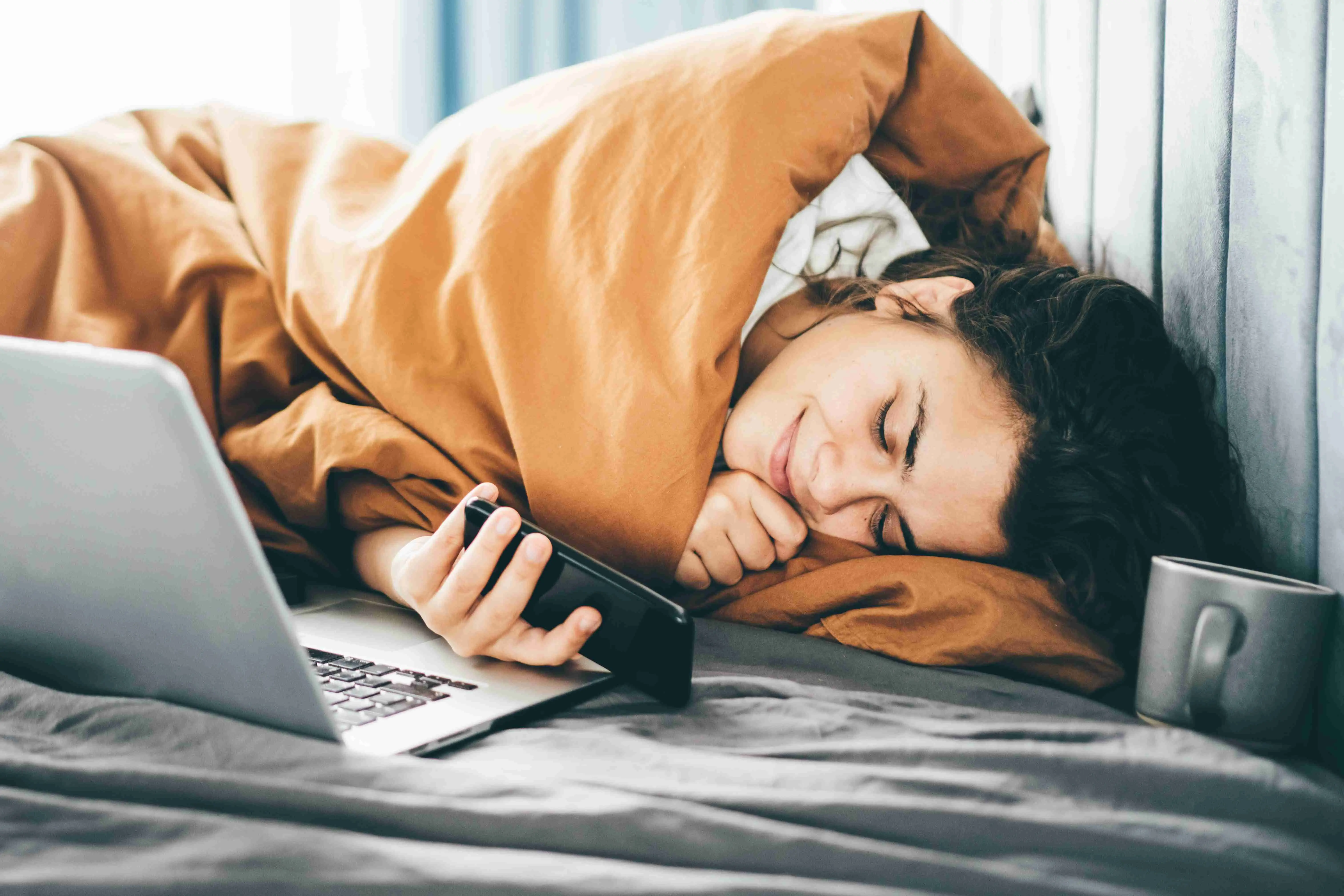 Woman using phone at the bed.