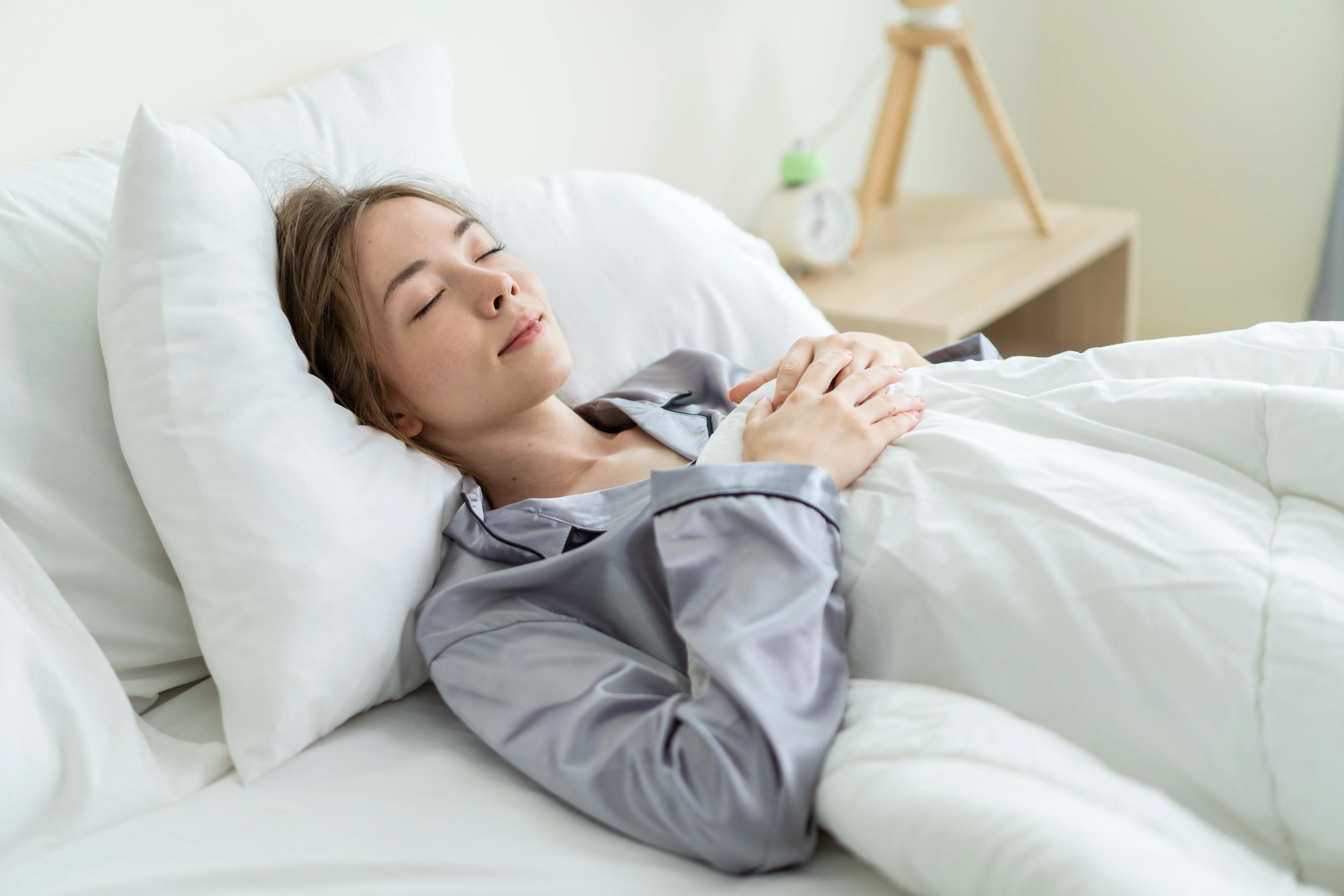 Beautiful Caucasian woman wearing pajamas sleeping in bedroom at home.