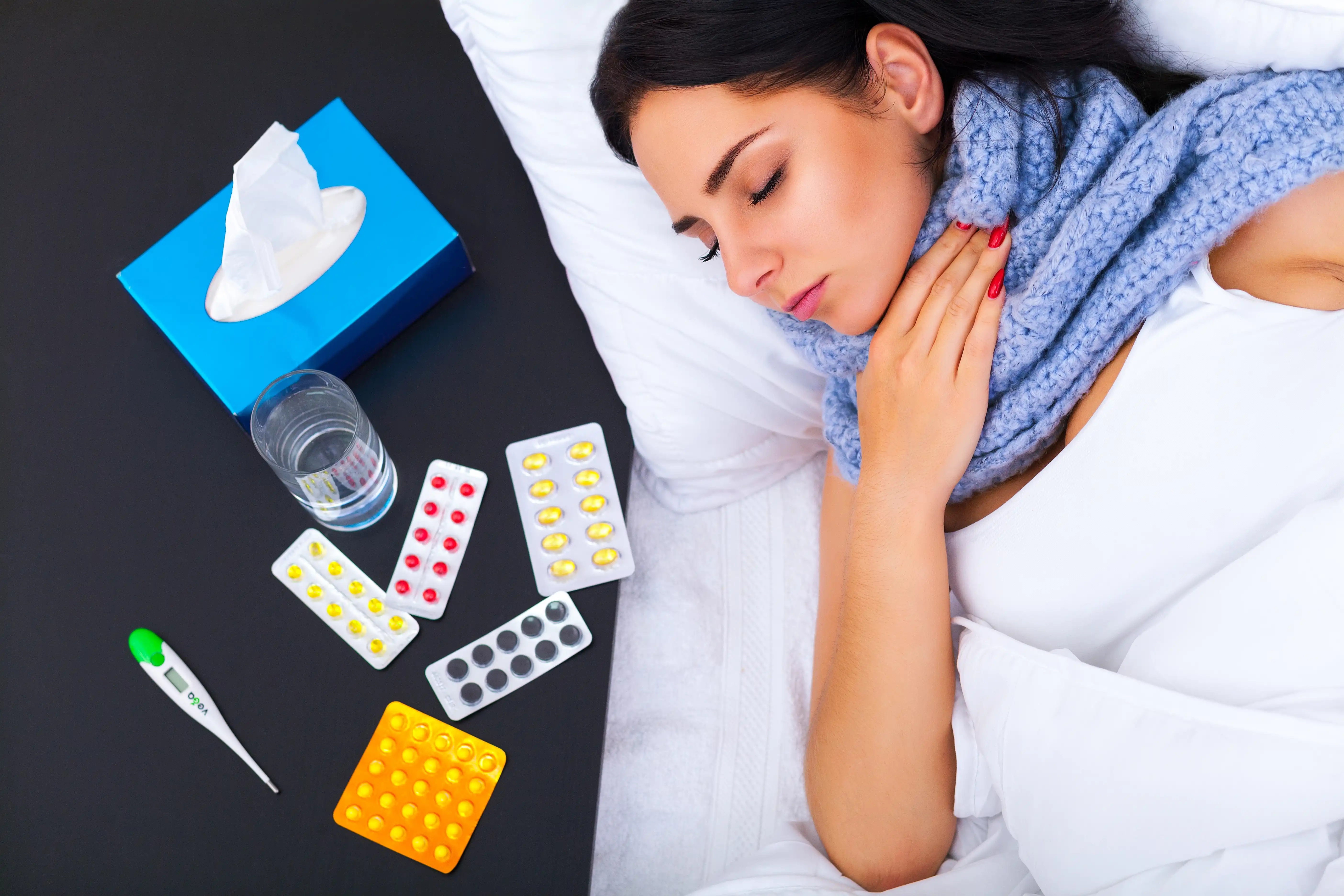 A woman with a cold is being treated at home in bed