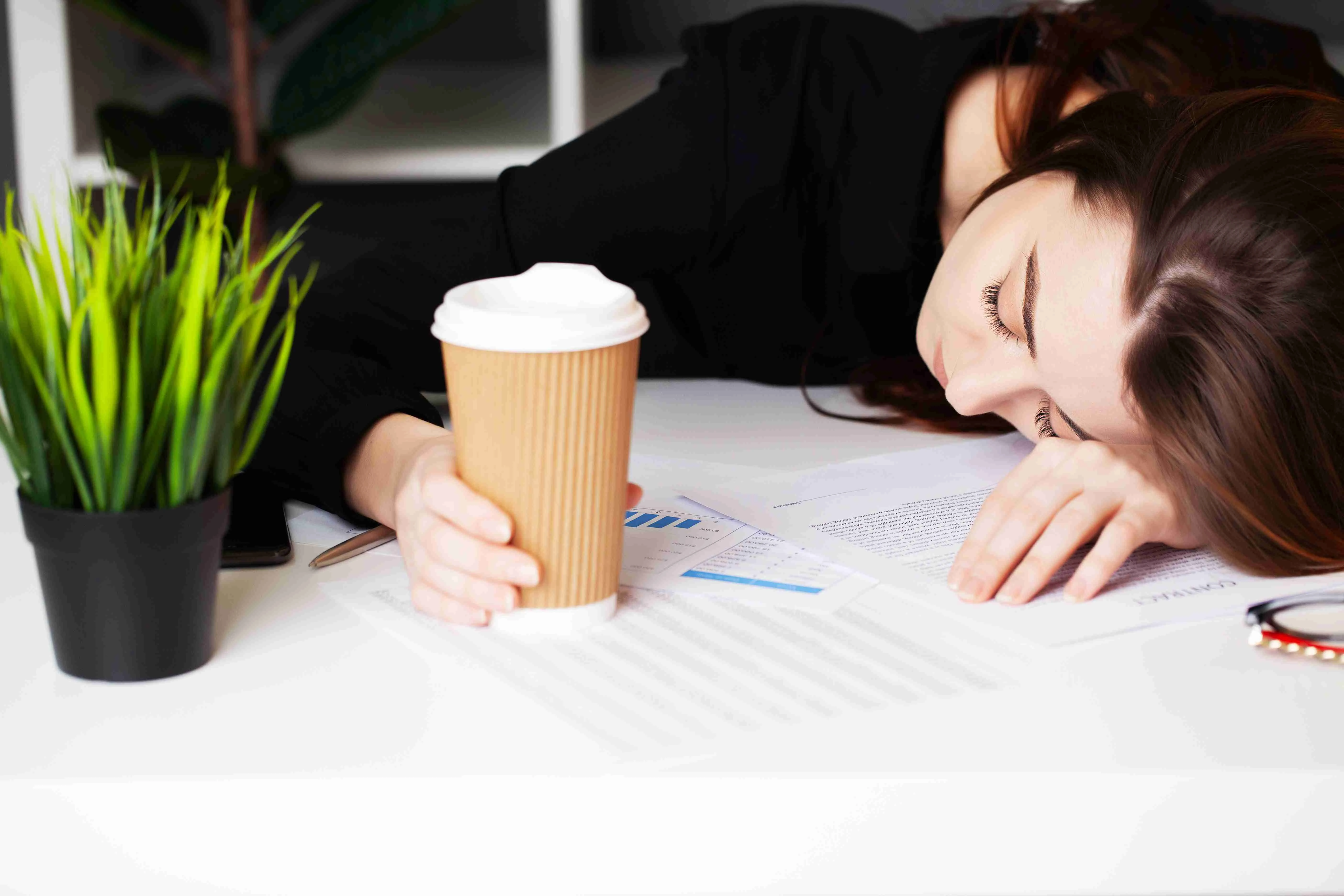 Tired woman working at company office at computer