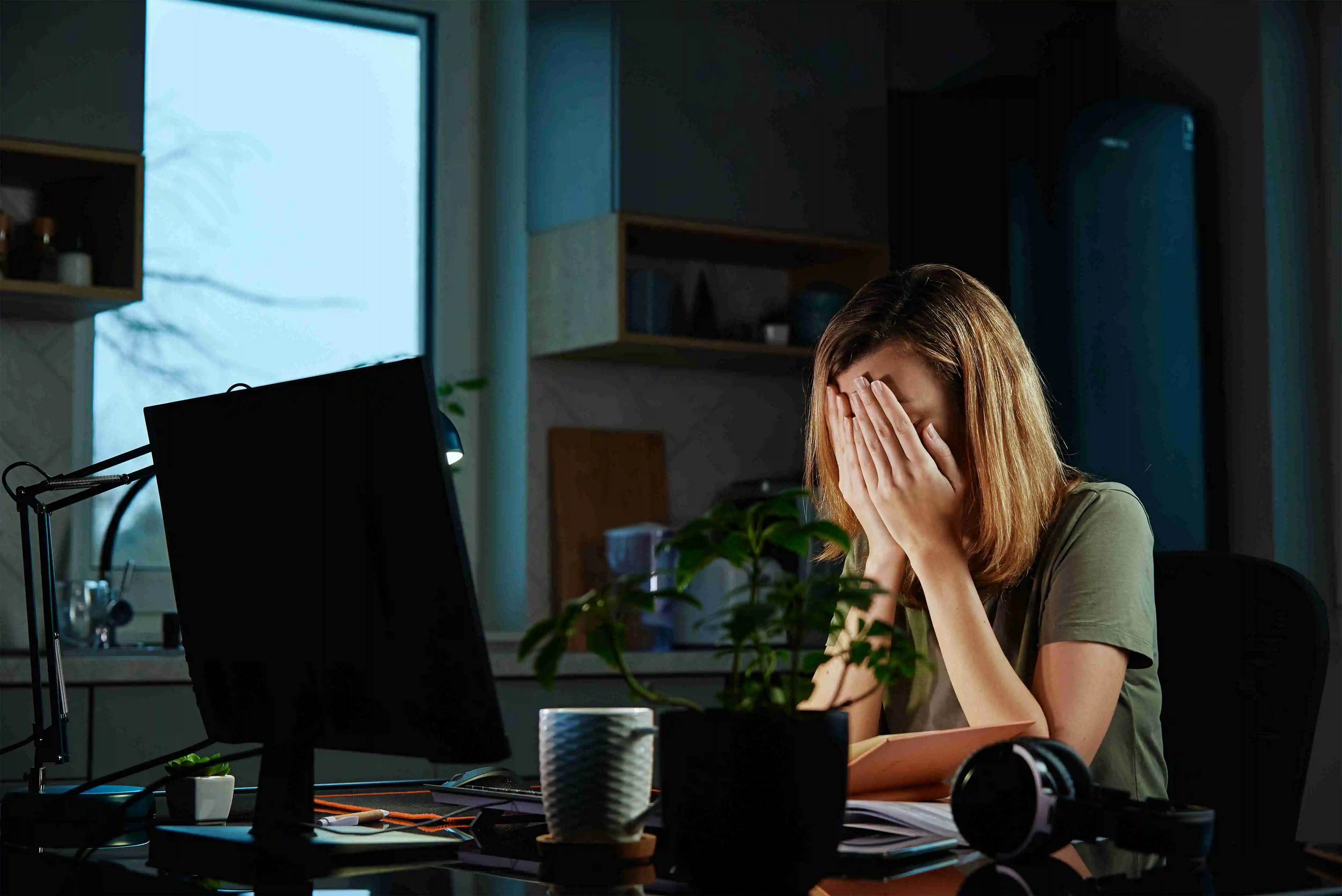 Tired woman works late at workplace in the night