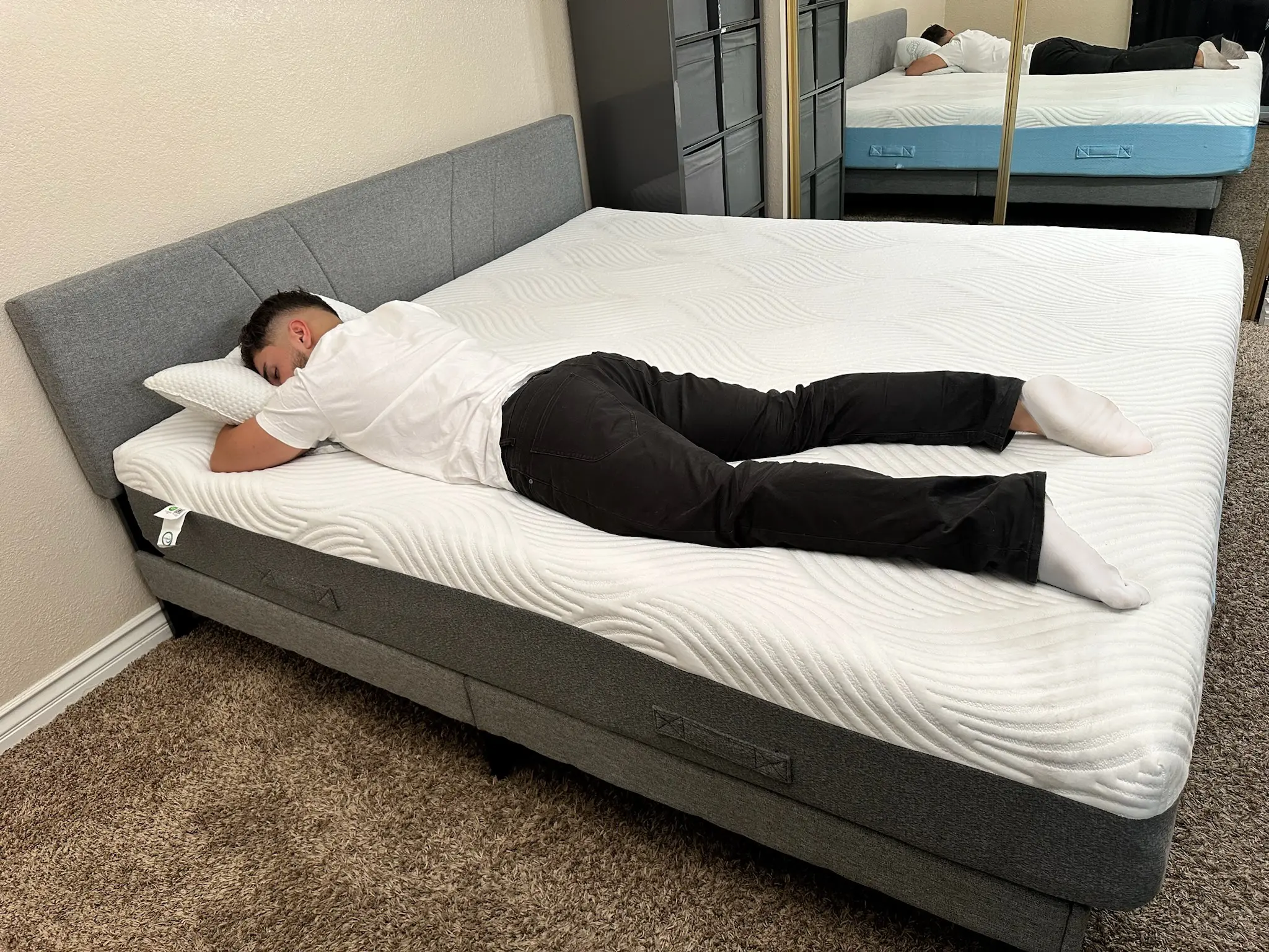 A reviewer is lying on a Minocasa Zero mattress in a mirrored room.