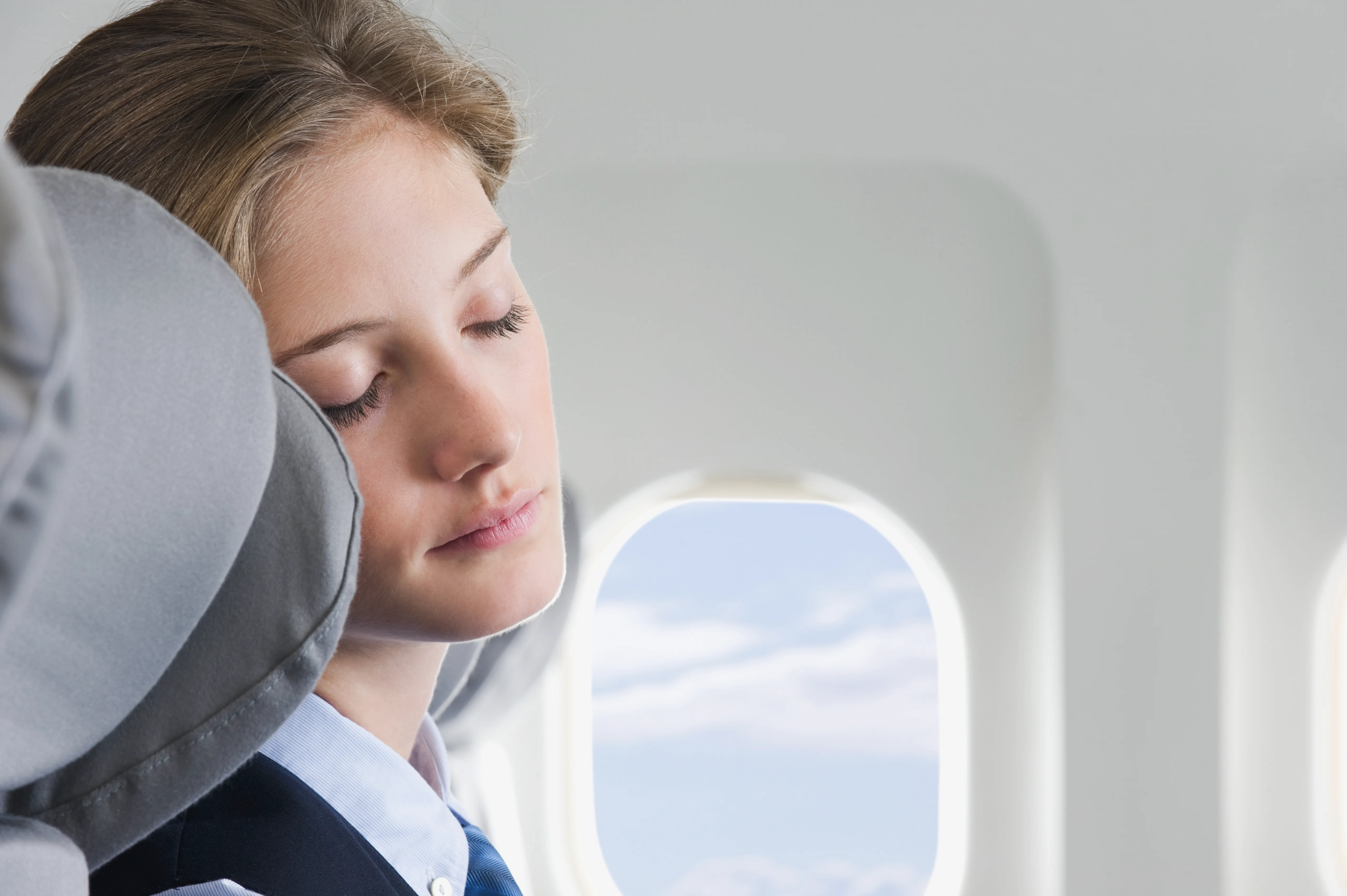 Close up of young stewardess sleeping in business class airplane cabin