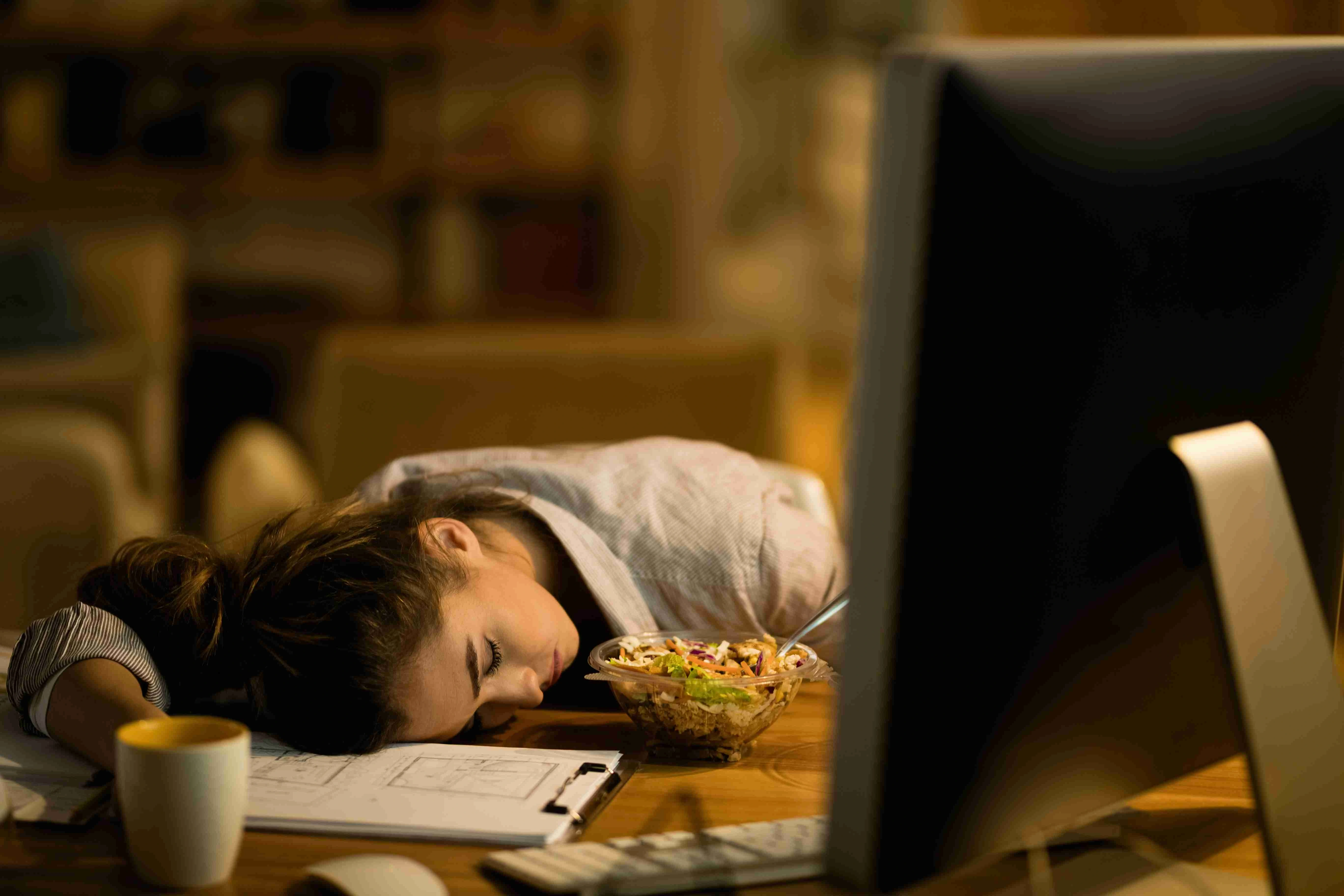 Exhausted woman fell asleep while working late on a computer at home