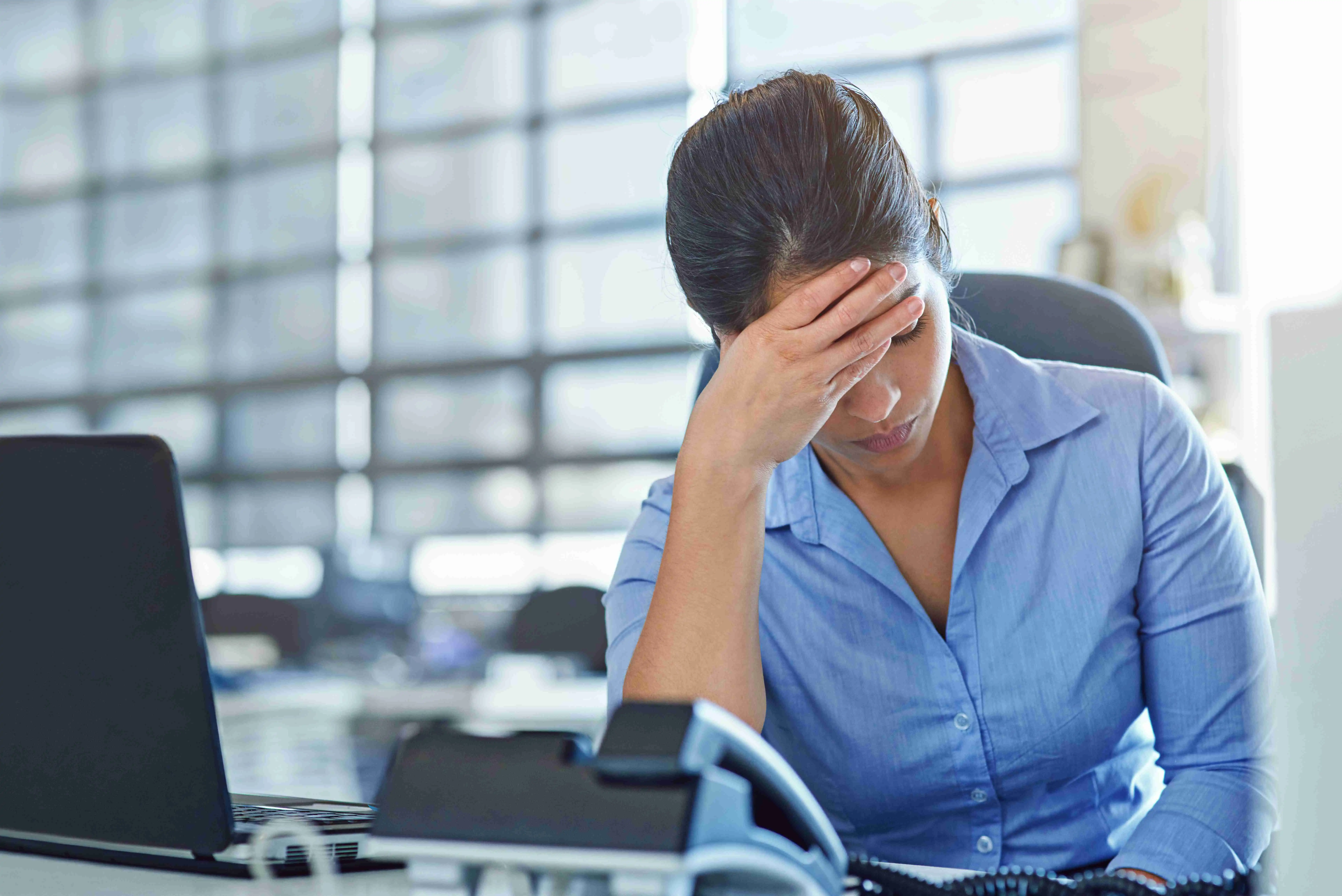 Shot of a businesswoman experiencing stress at work.