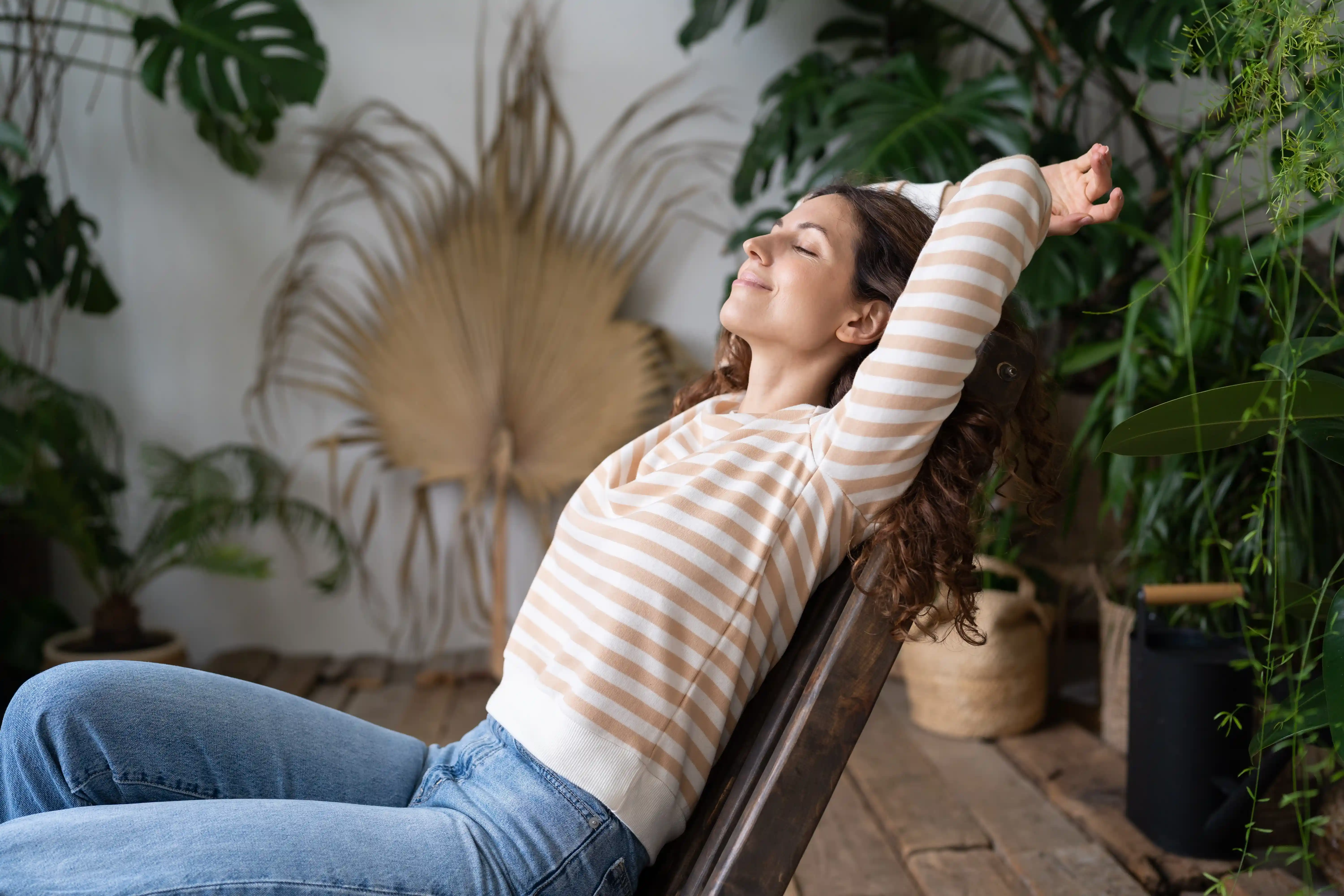 A woman sitting quietly in an indoor garden