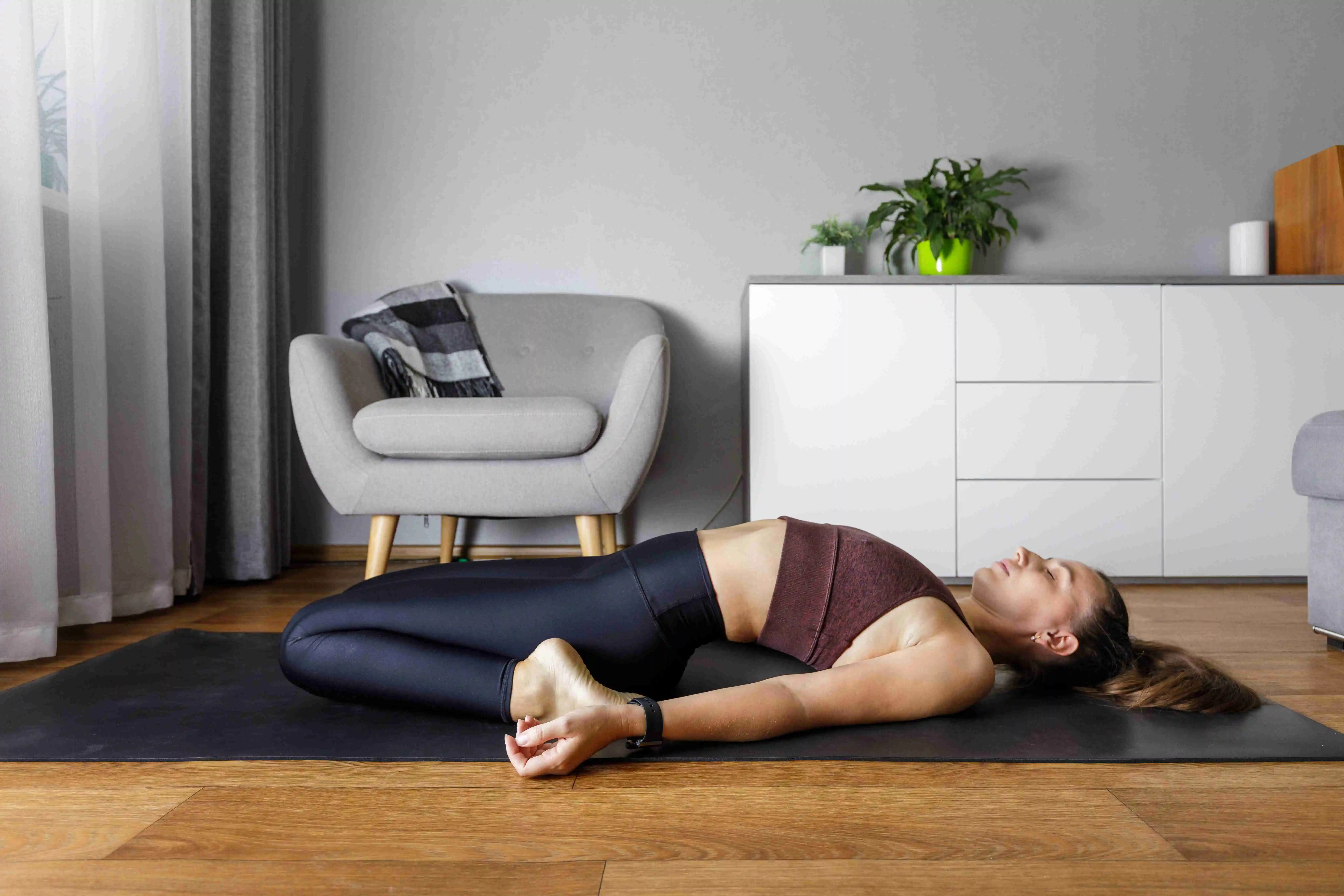 Young yogi woman practicing yoga at home.