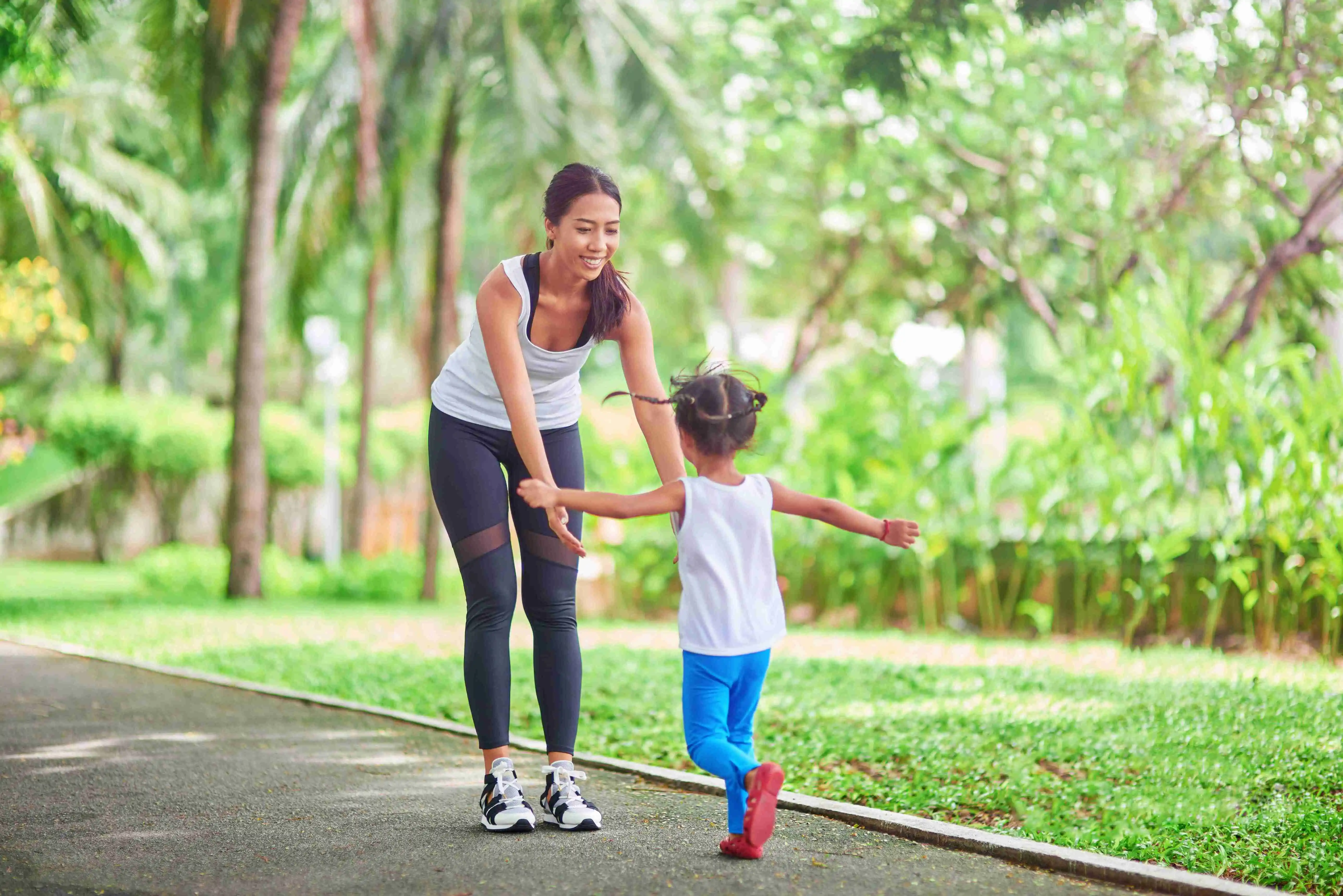 Positive little girl running in front of her mother