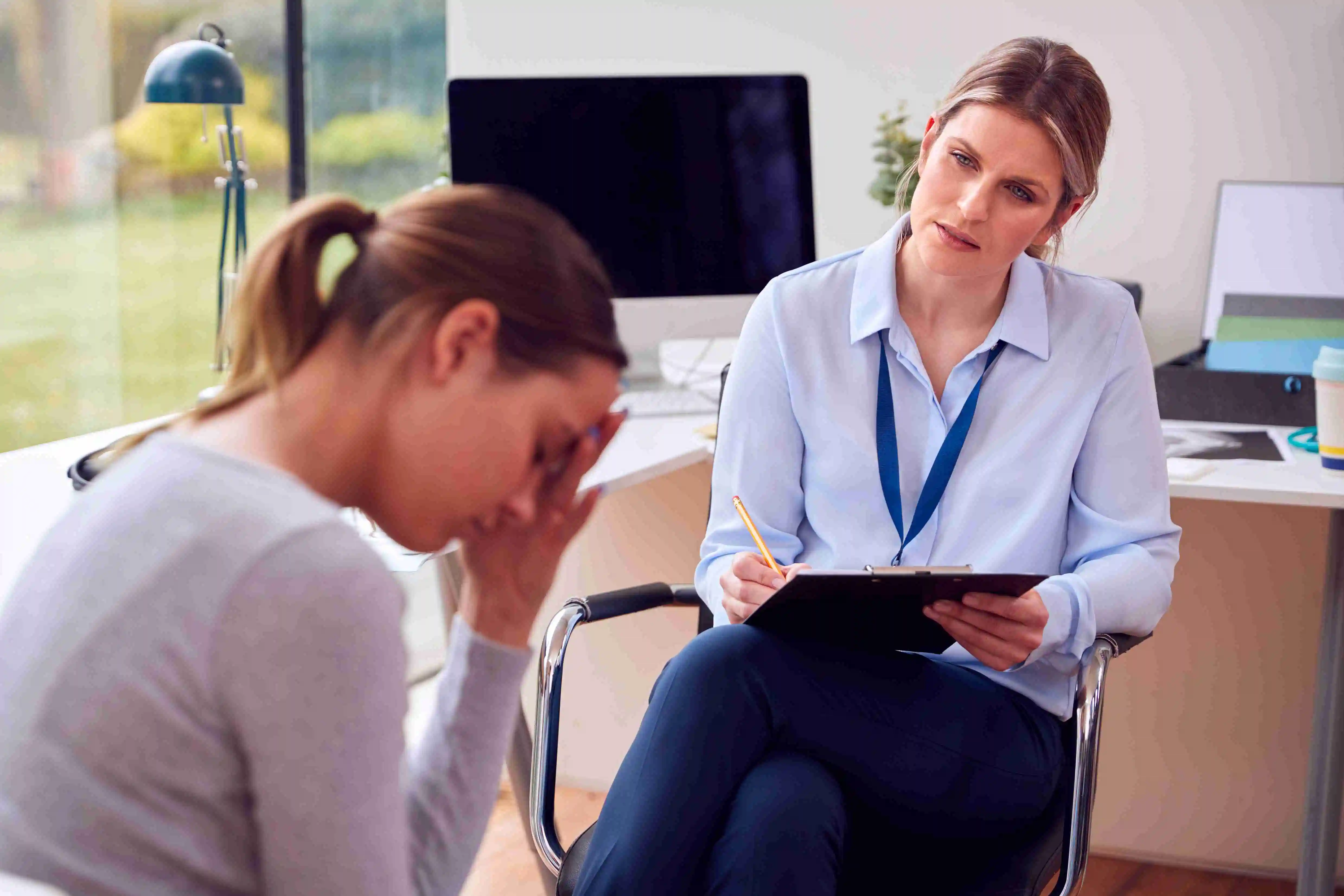 Doctor In Office Meeting Teenage Female Patient with Mental Health Problems for Appointment