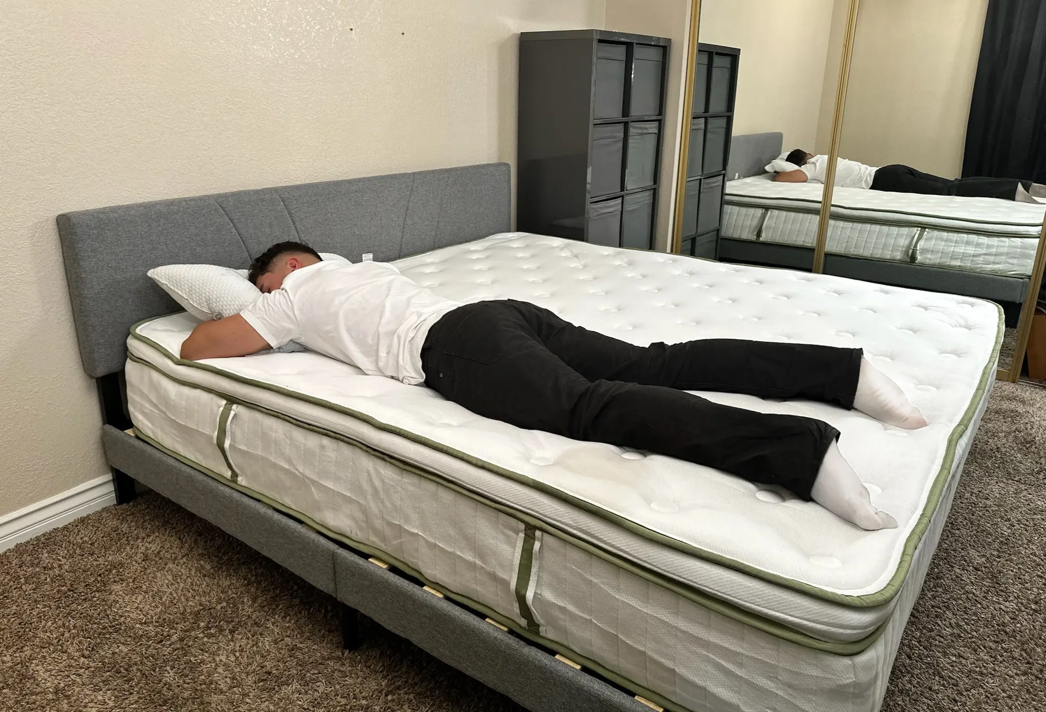 A reviewer is lying on a Silk & Snow organic mattress in a mirrored room.