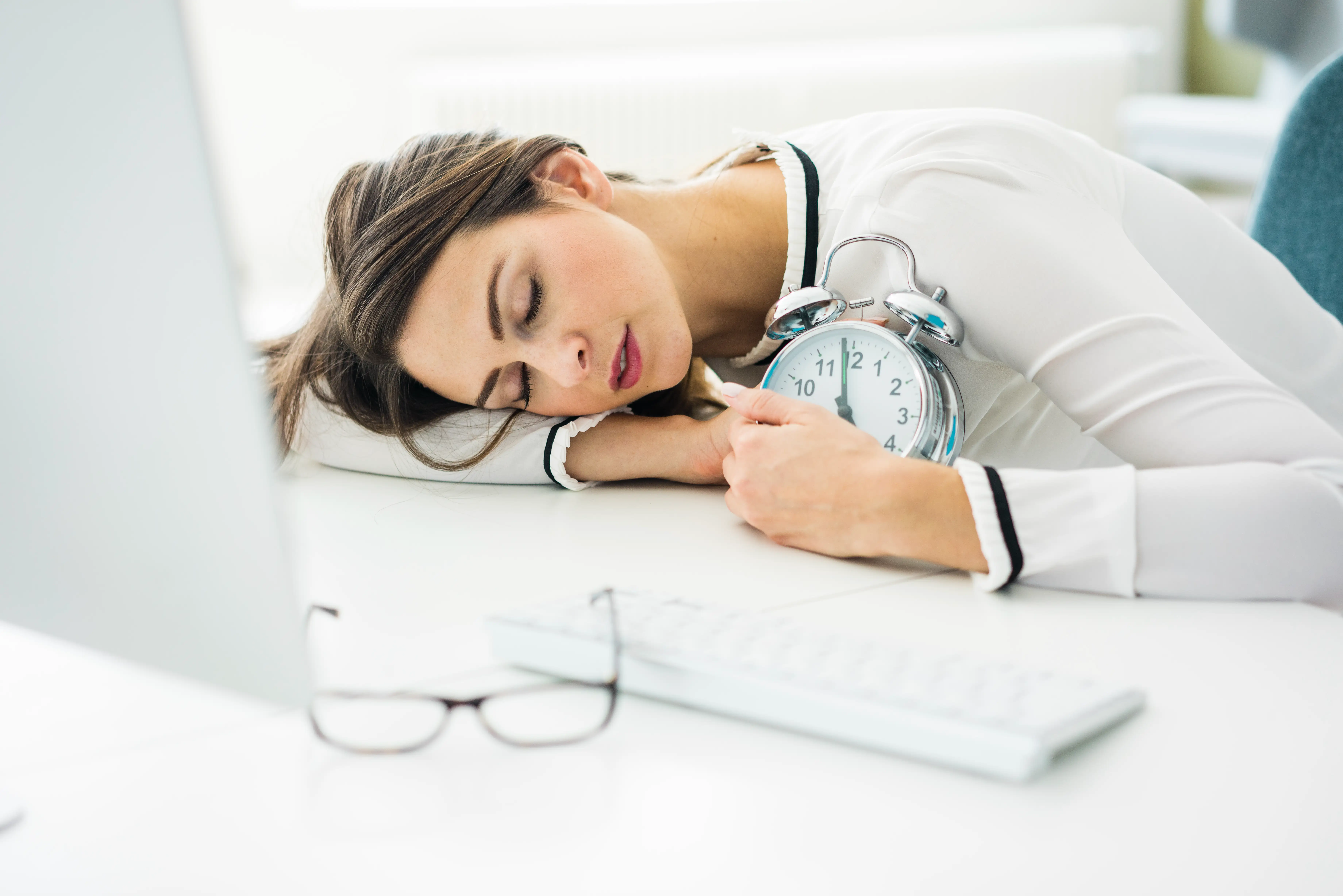 Overworked woman sleeping on desk in office