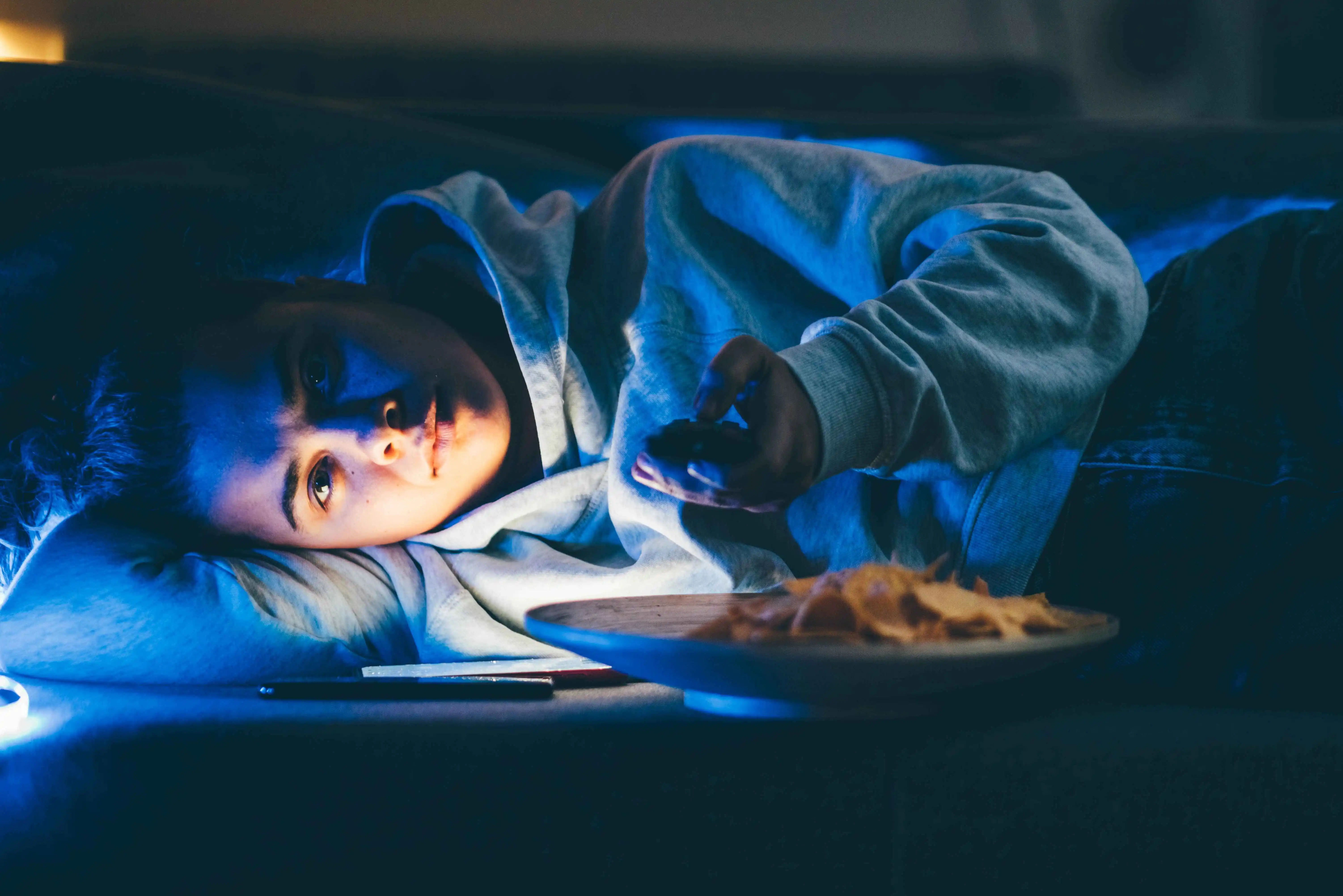 Woman watching tv and eating.