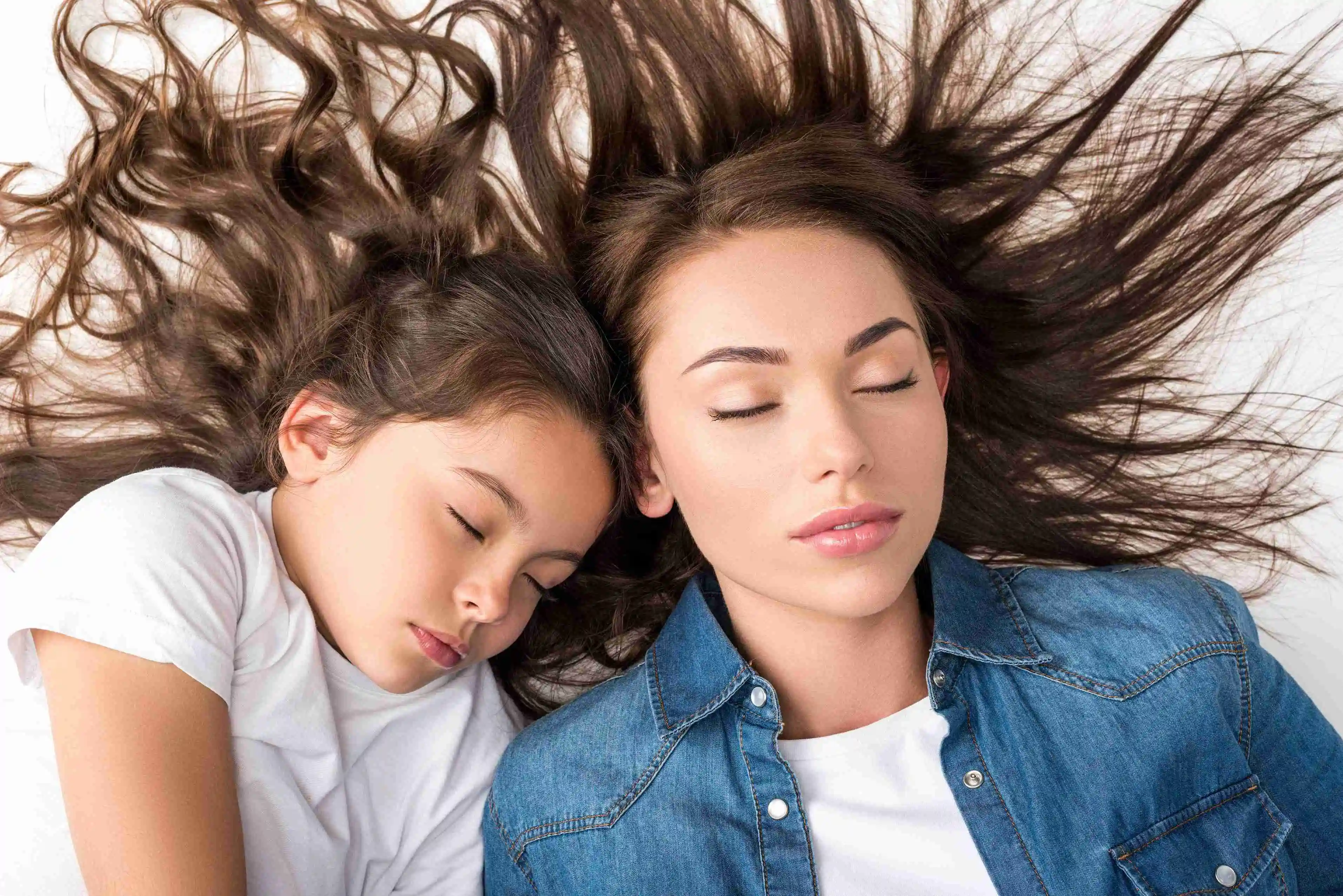 Top view of mother and daughter sleeping isolated on white