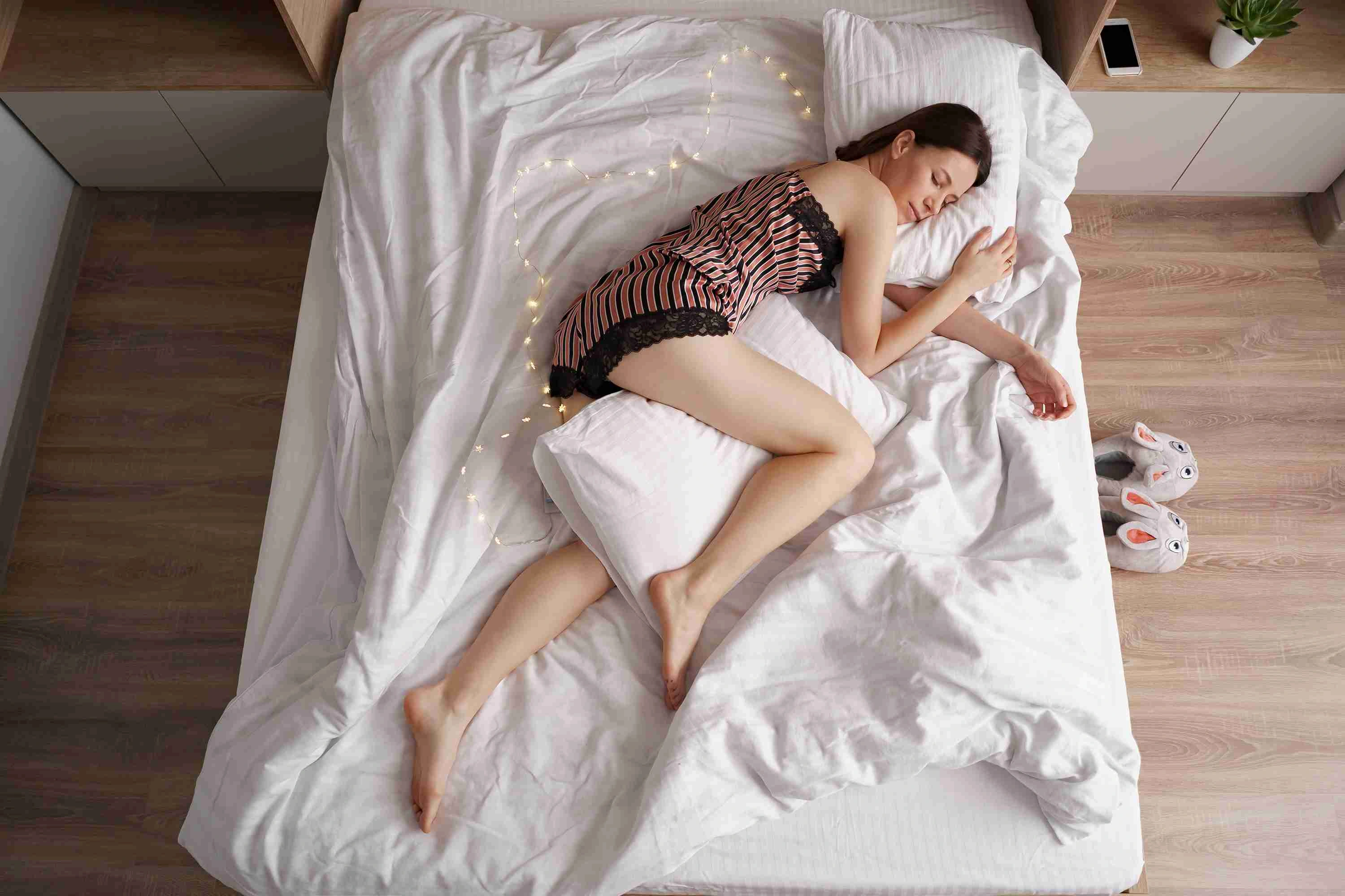  Lady enjoys fresh soft bedding linen and mattress in bedroom