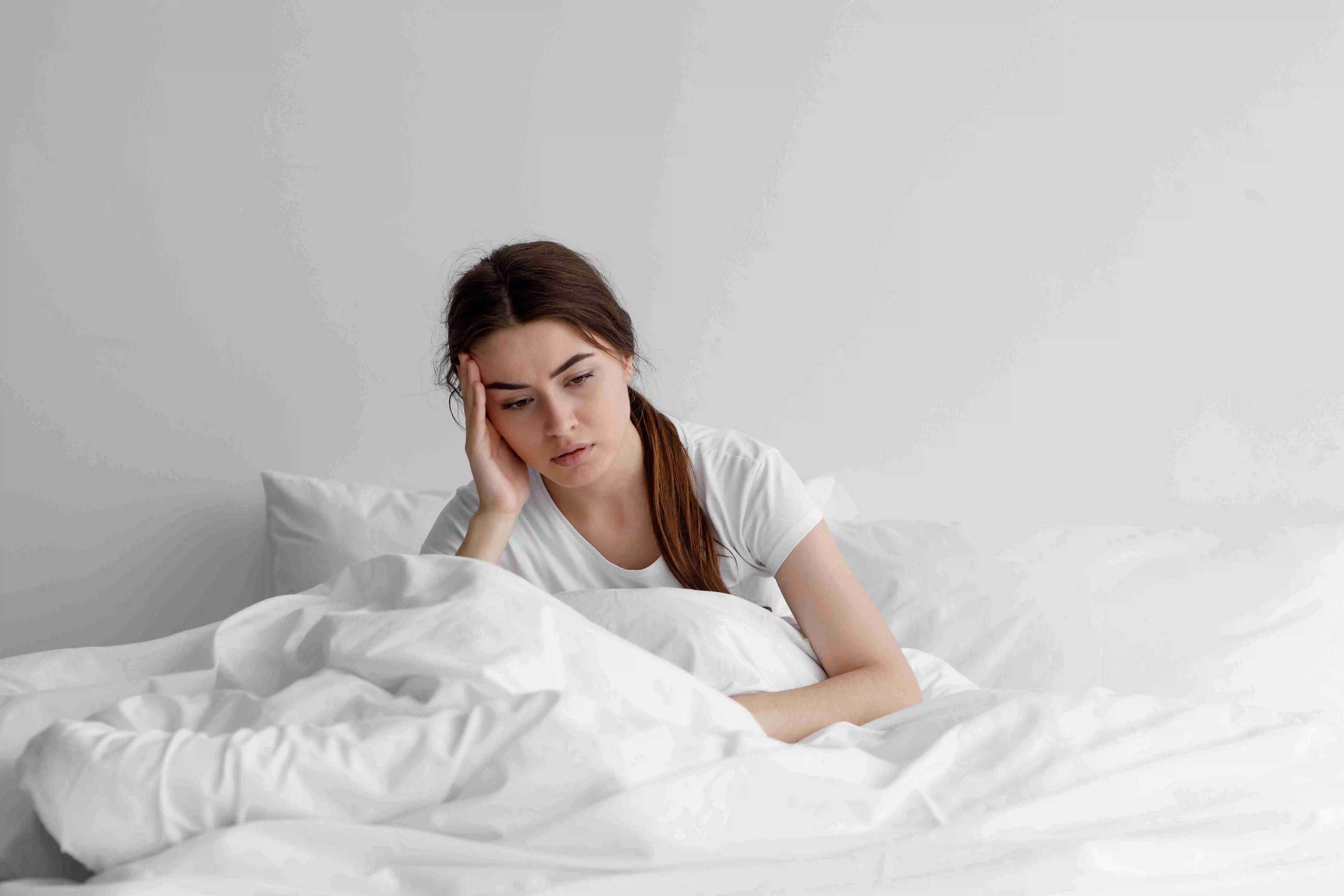 Lady sits on bed in bedroom at home