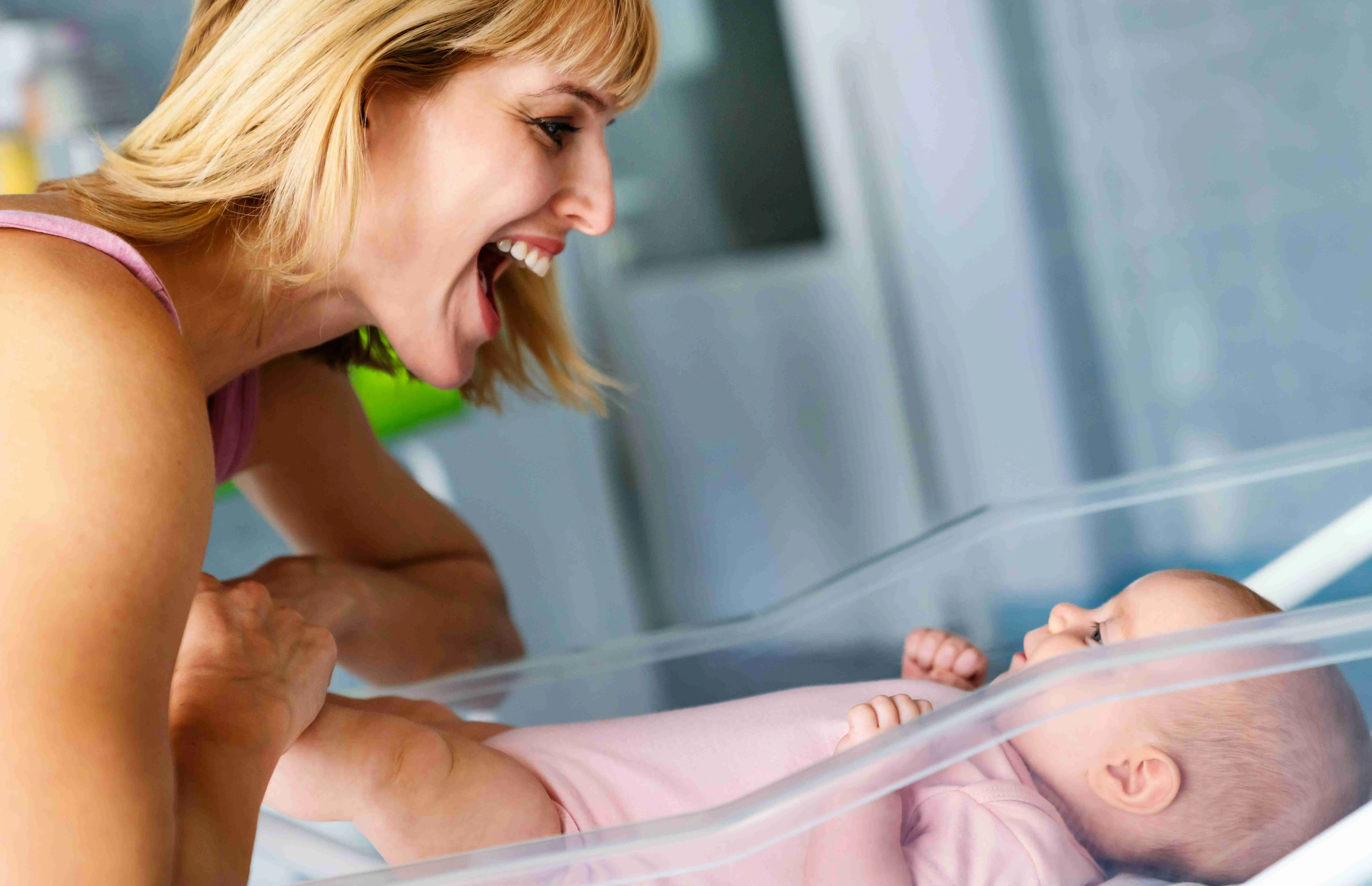Mother and baby kissing, laughing and hugging
