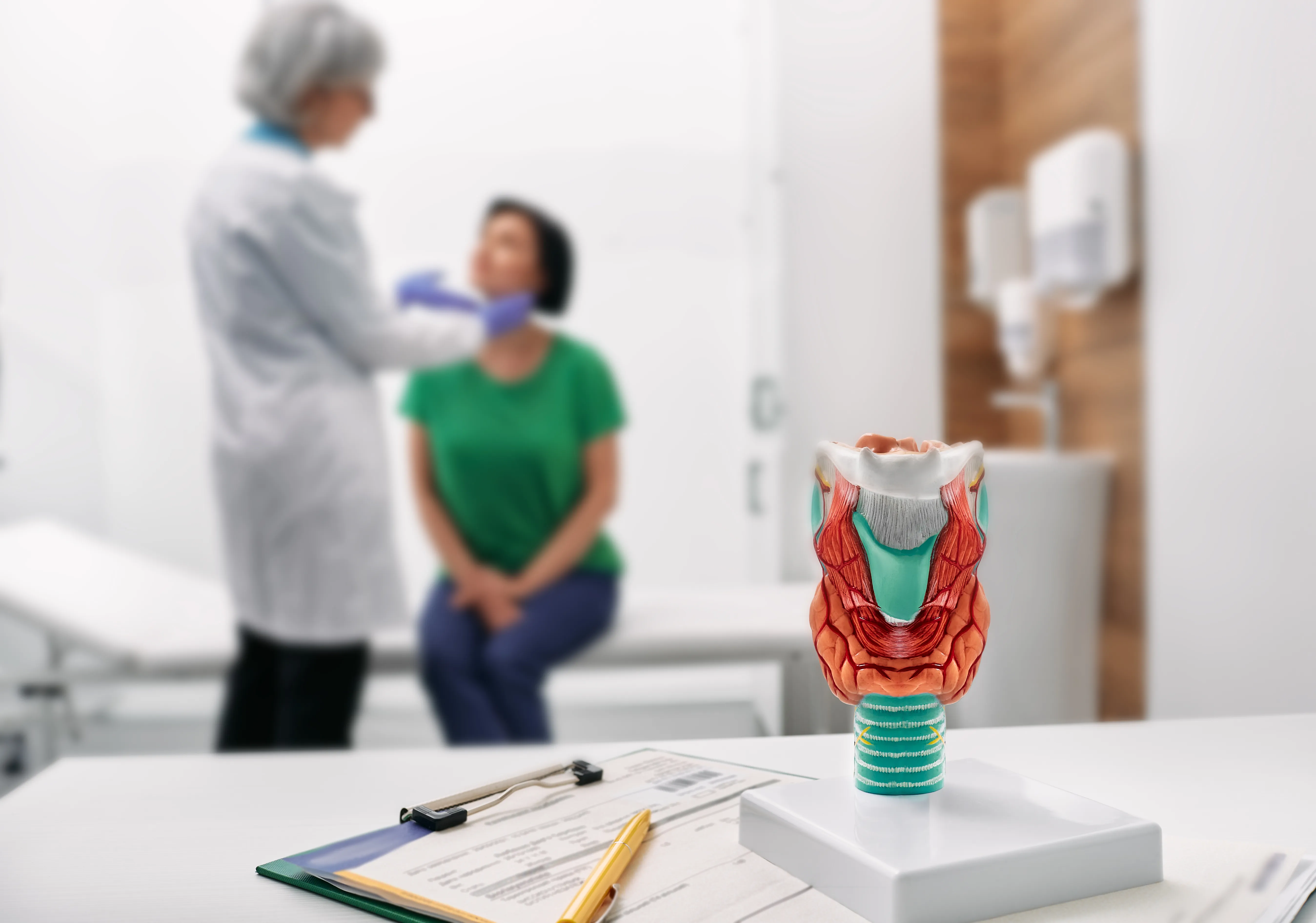 Doctor palpates of woman's neck for diagnostics of thyroid diseases. Thyroid gland exam and treatment