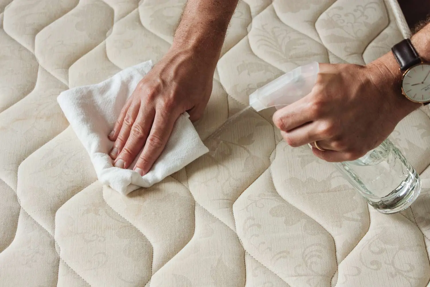 a man cleaning mattress with cleaning products