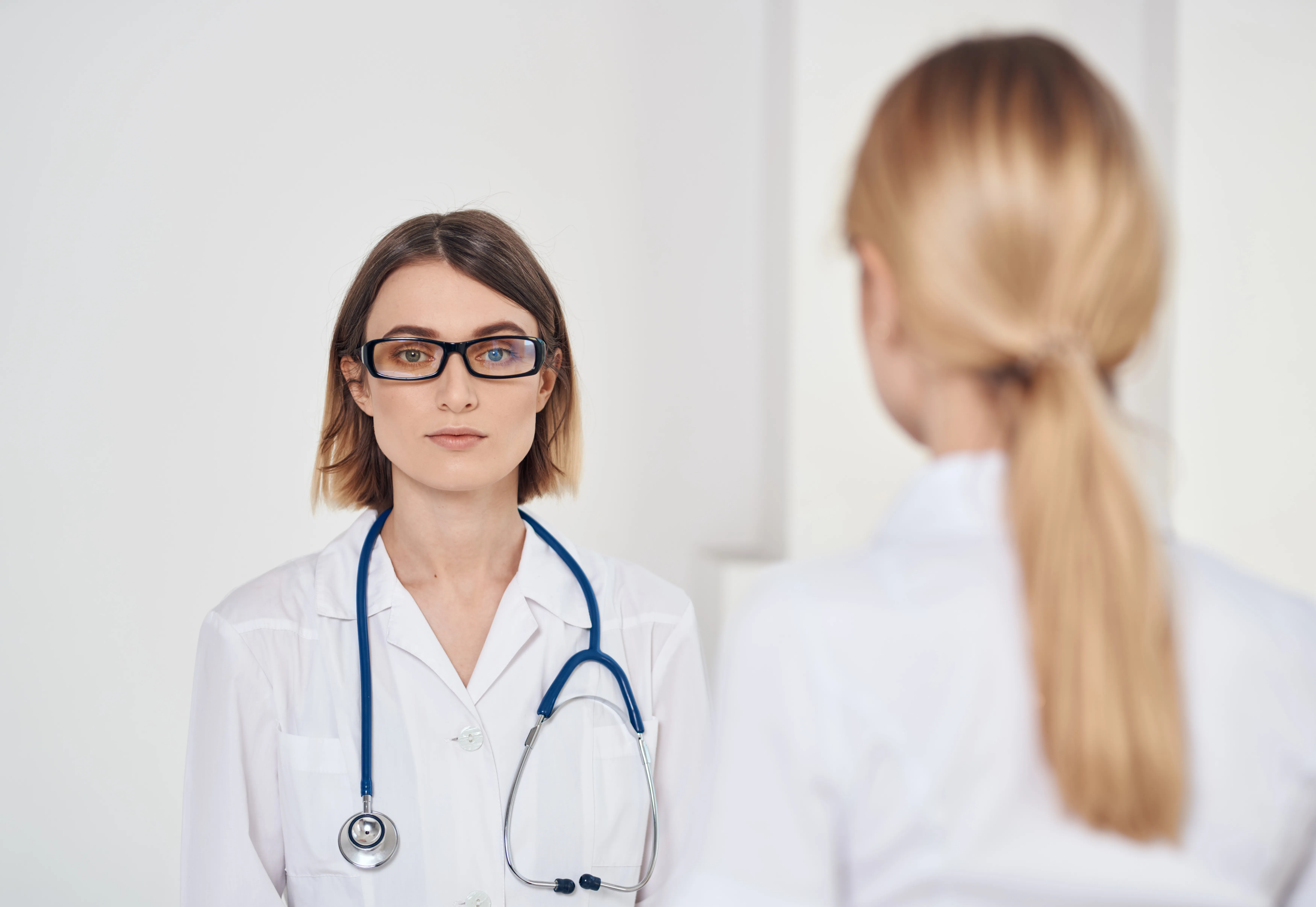 professional doctor with a stethoscope explaining something to a patient in a t-shirt