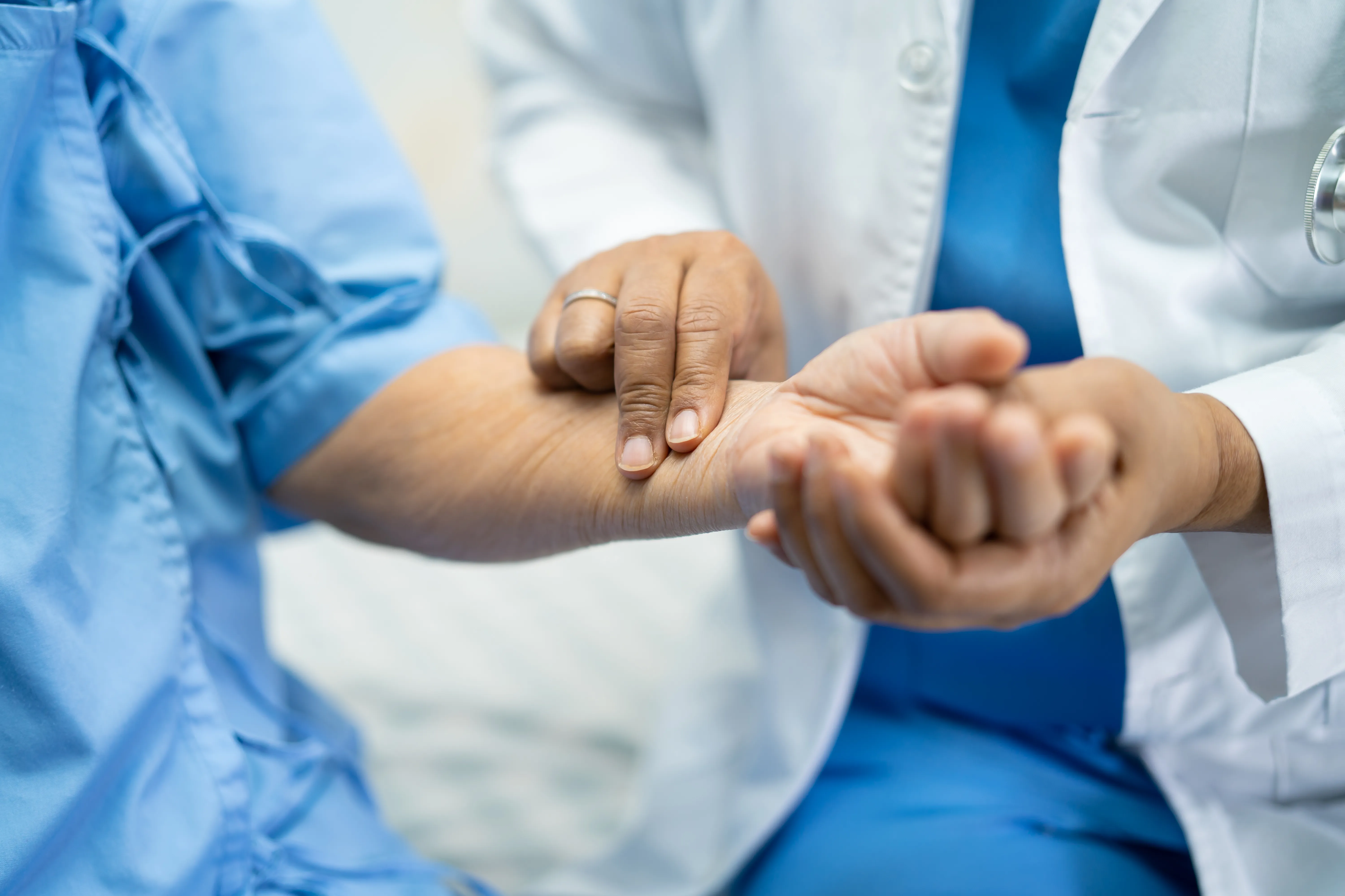 Doctor catch the pulse with patient in nursing hospital ward, healthy strong medical concept.