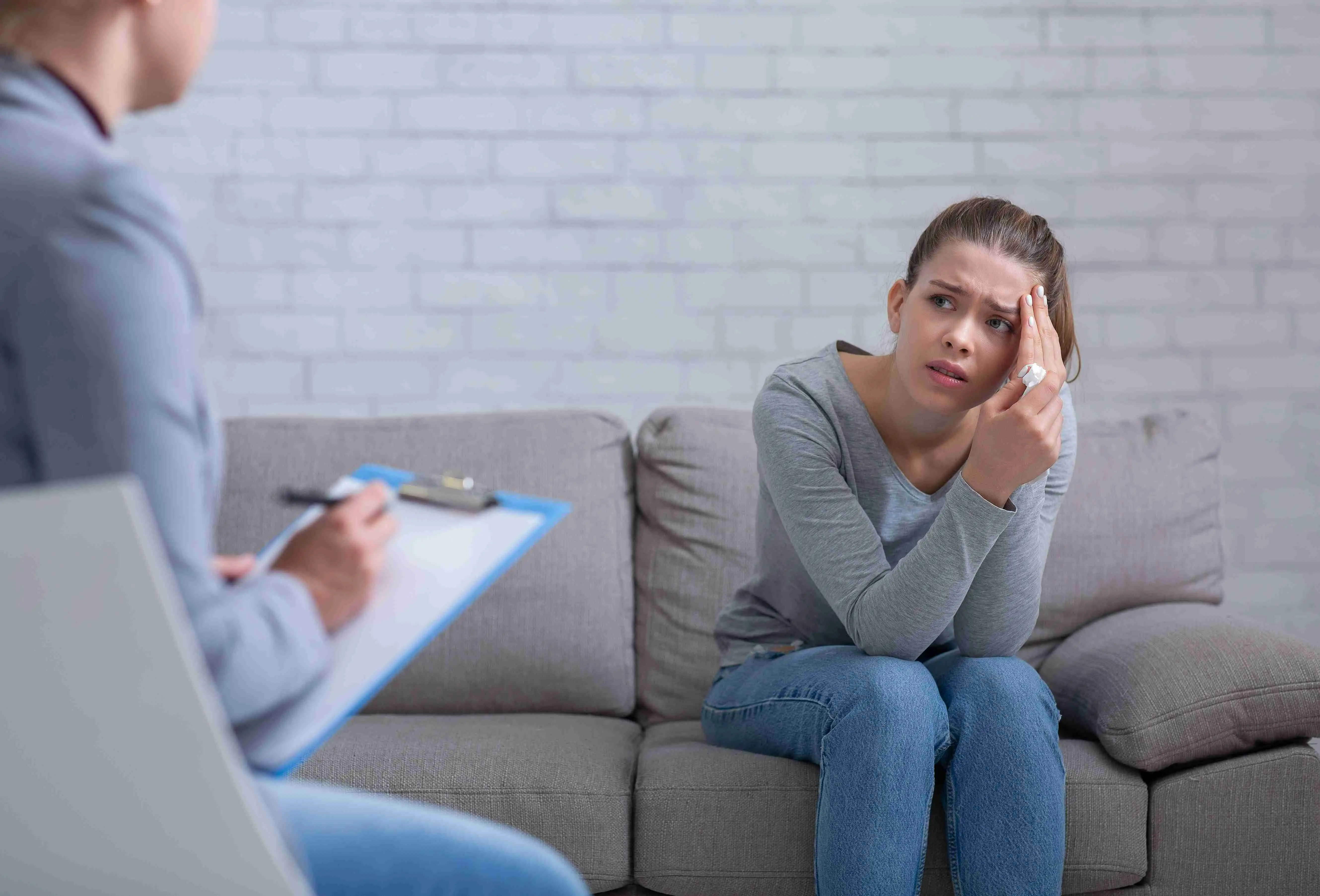 Female patient with depression having session with her psychotherapist at office